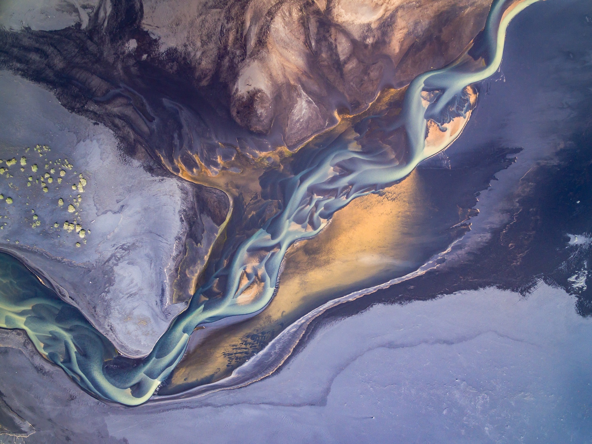 Aerial view of braided river delta with colorful sediment HD Wallpaper