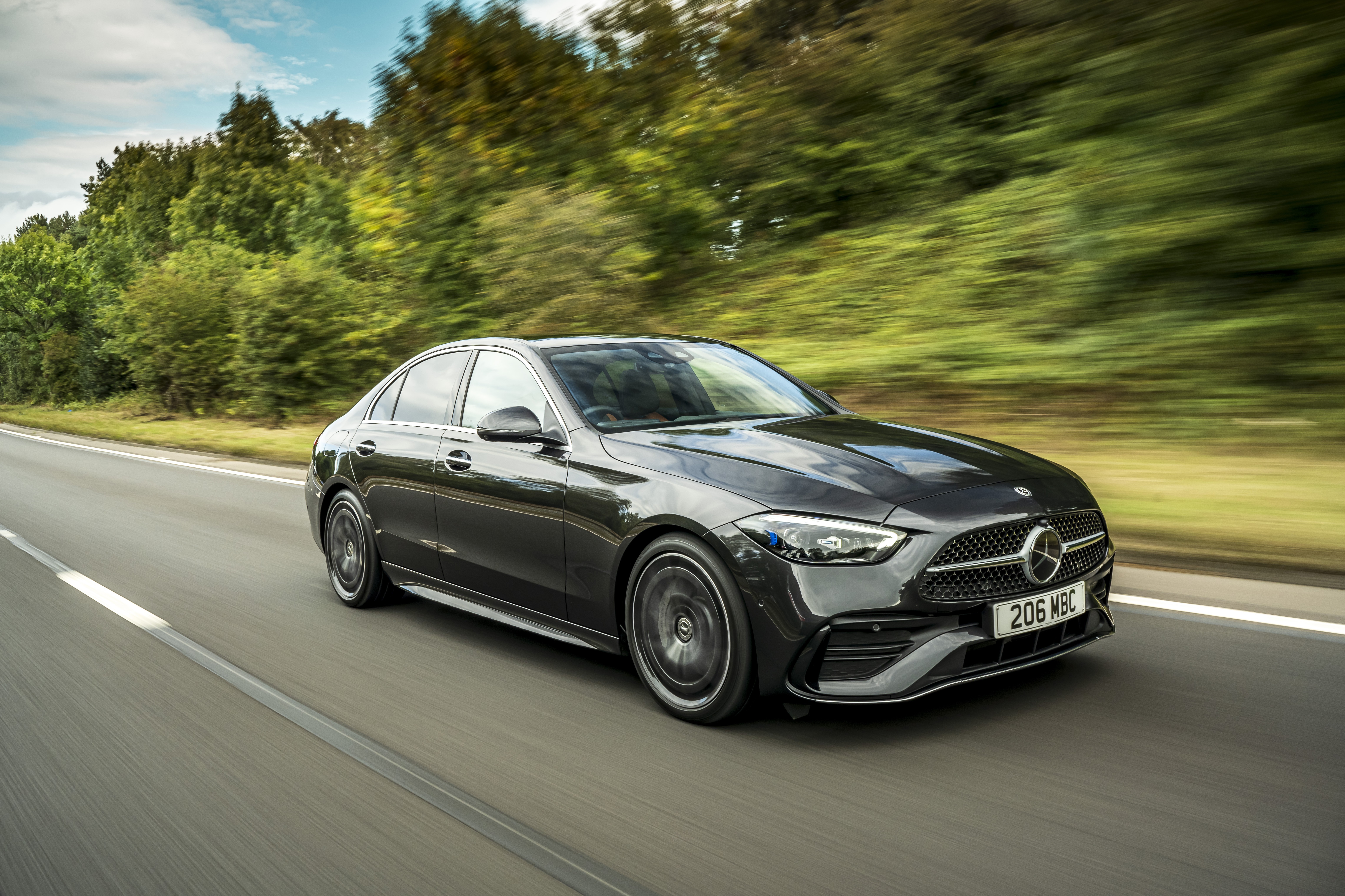Mercedes-Benz C 300 d AMG Line driving on a road HD Wallpaper