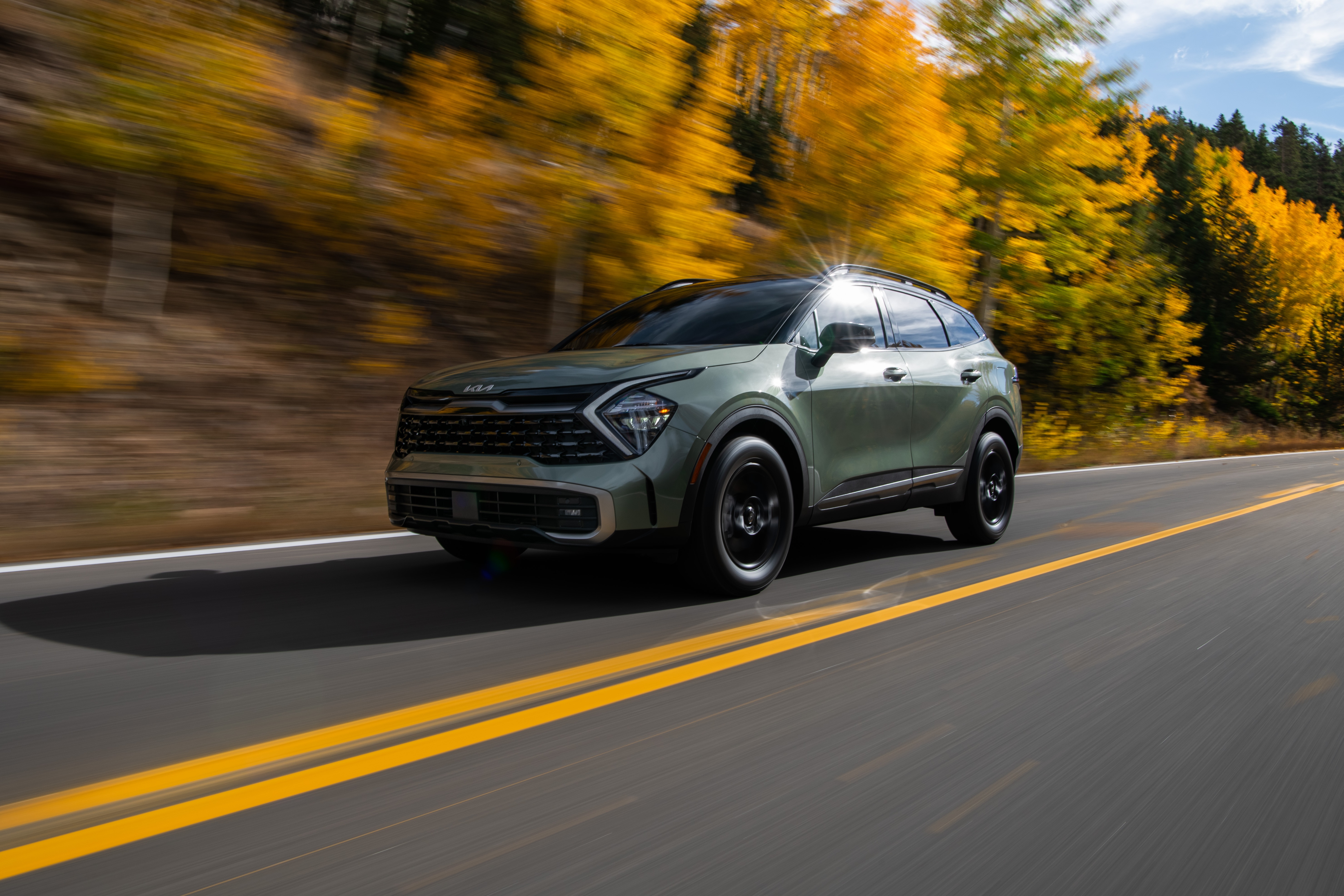 Green Kia Sportage X-Pro 4K driving on a road HD Wallpaper