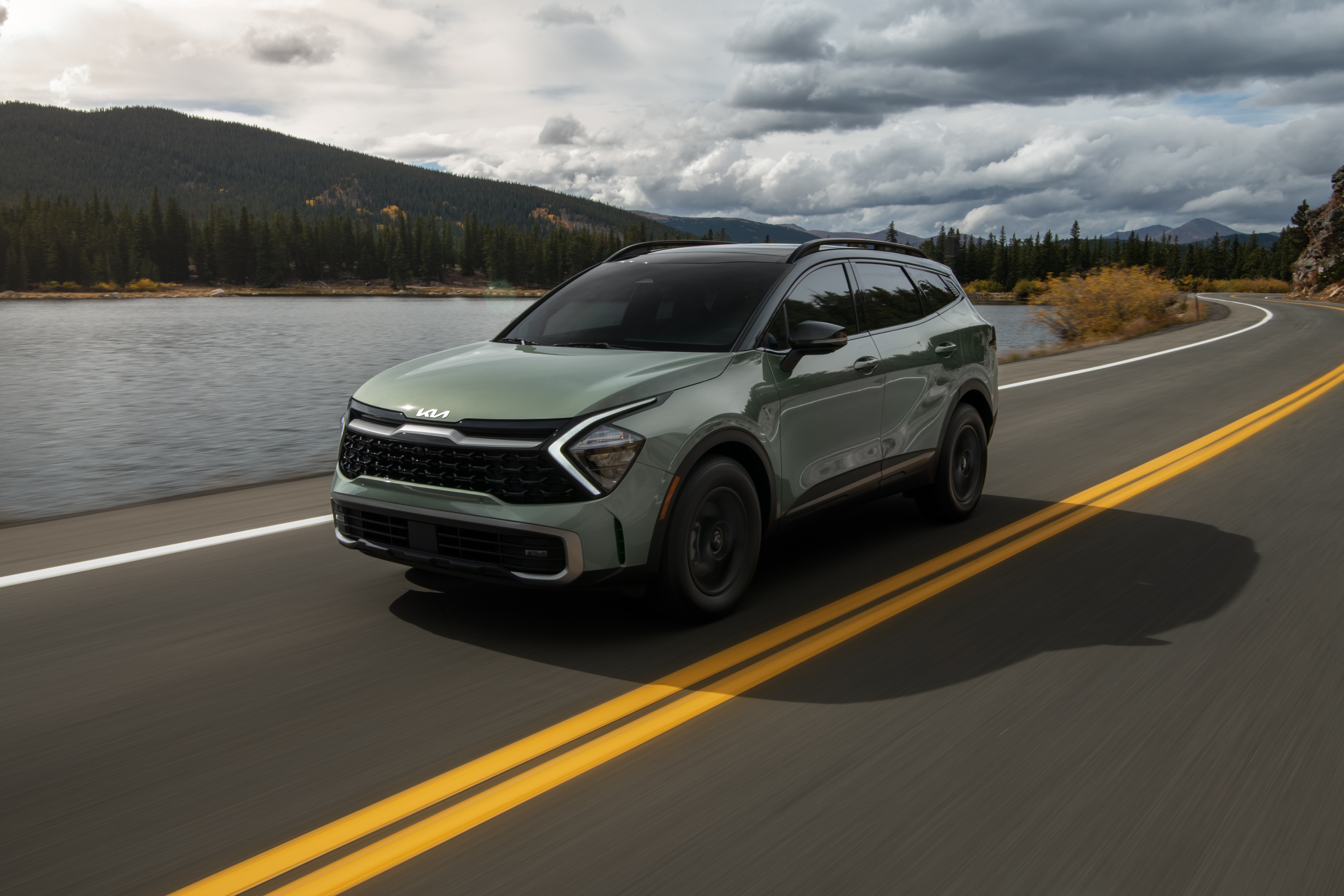 Green Kia Sportage X-Pro 4K driving on a road HD Wallpaper