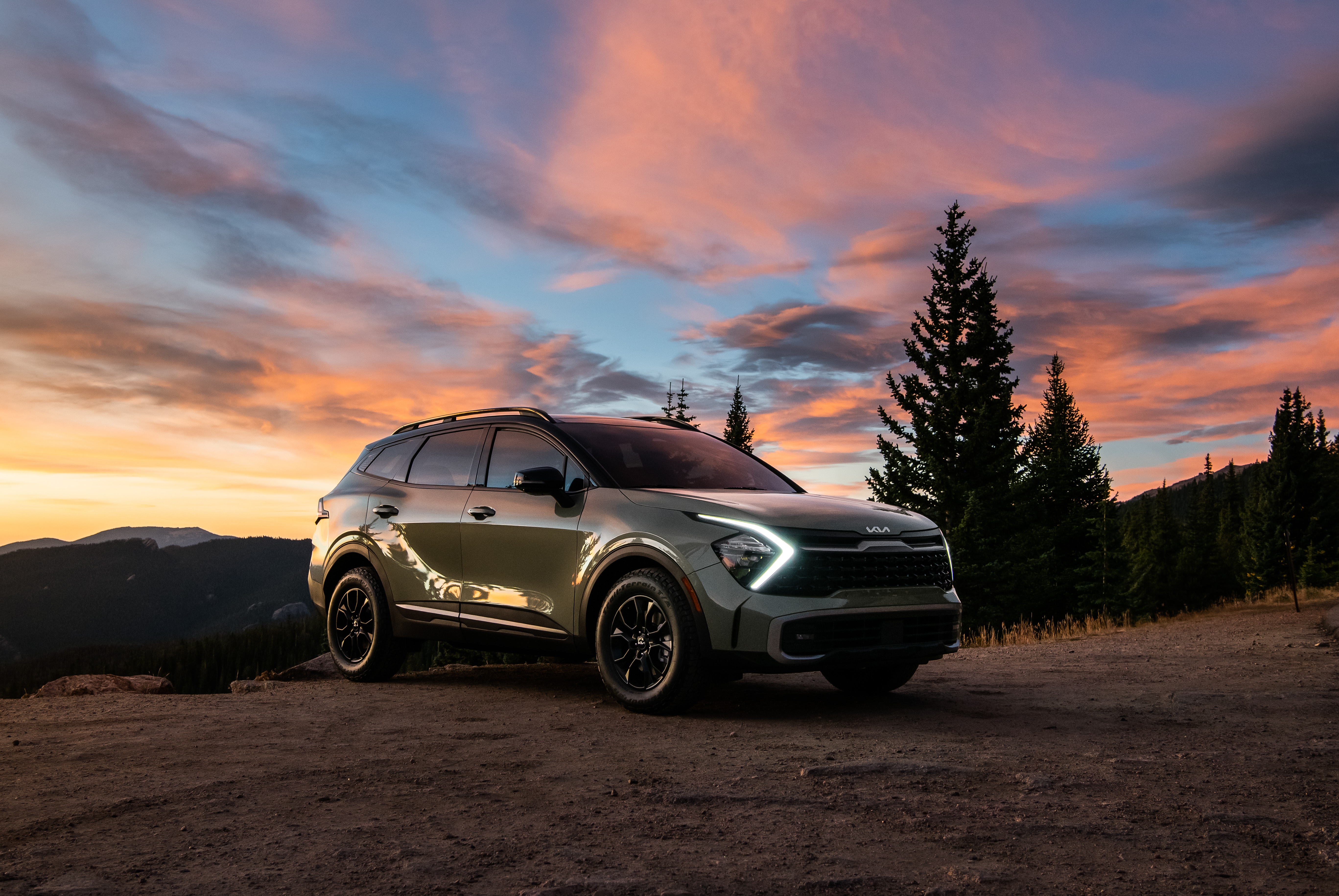 Kia Sportage X-Pro 4K SUV on mountain road at sunset HD Wallpaper