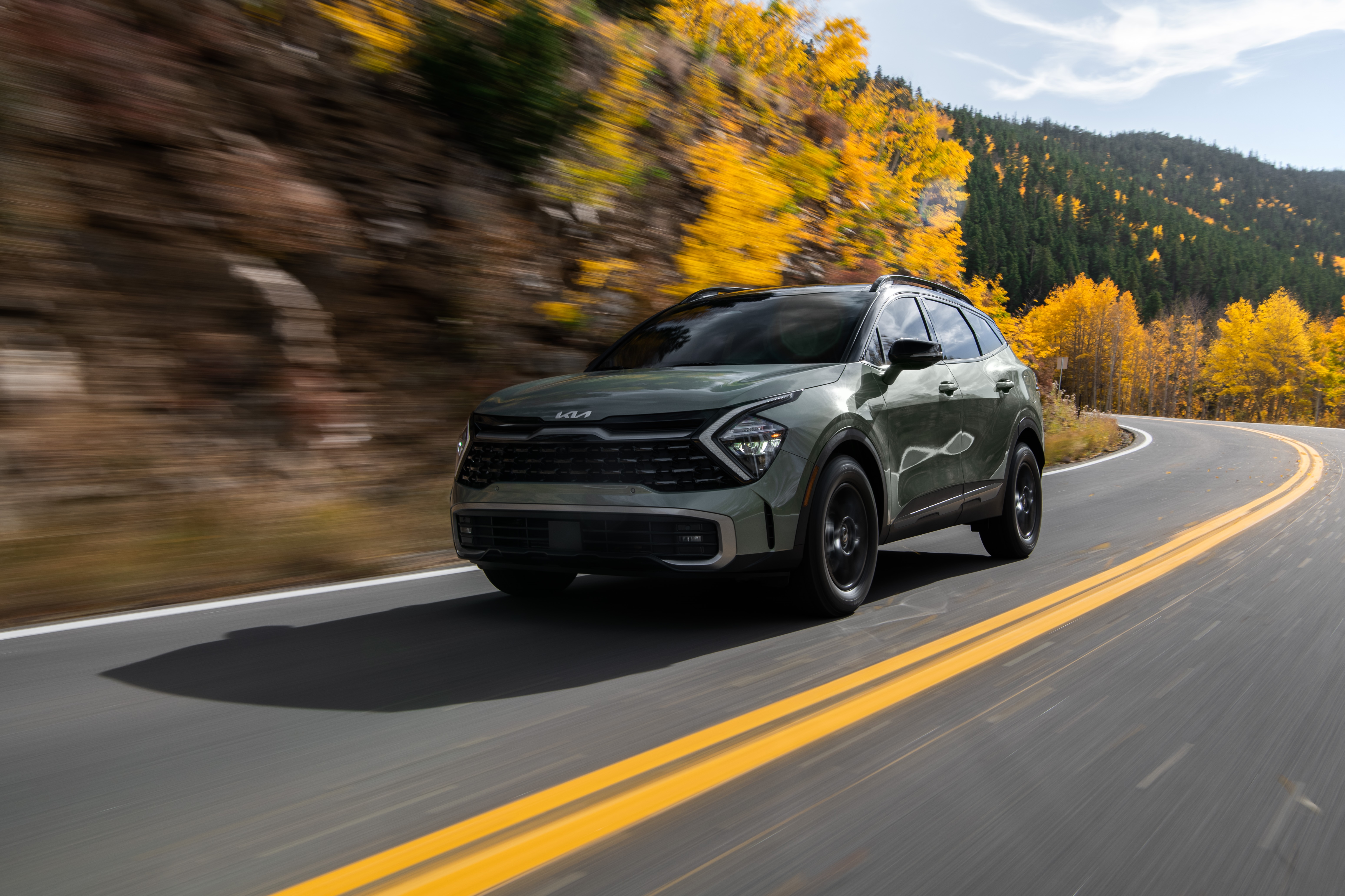 Green Kia Sportage X-Pro 4K driving on a mountain road HD Wallpaper