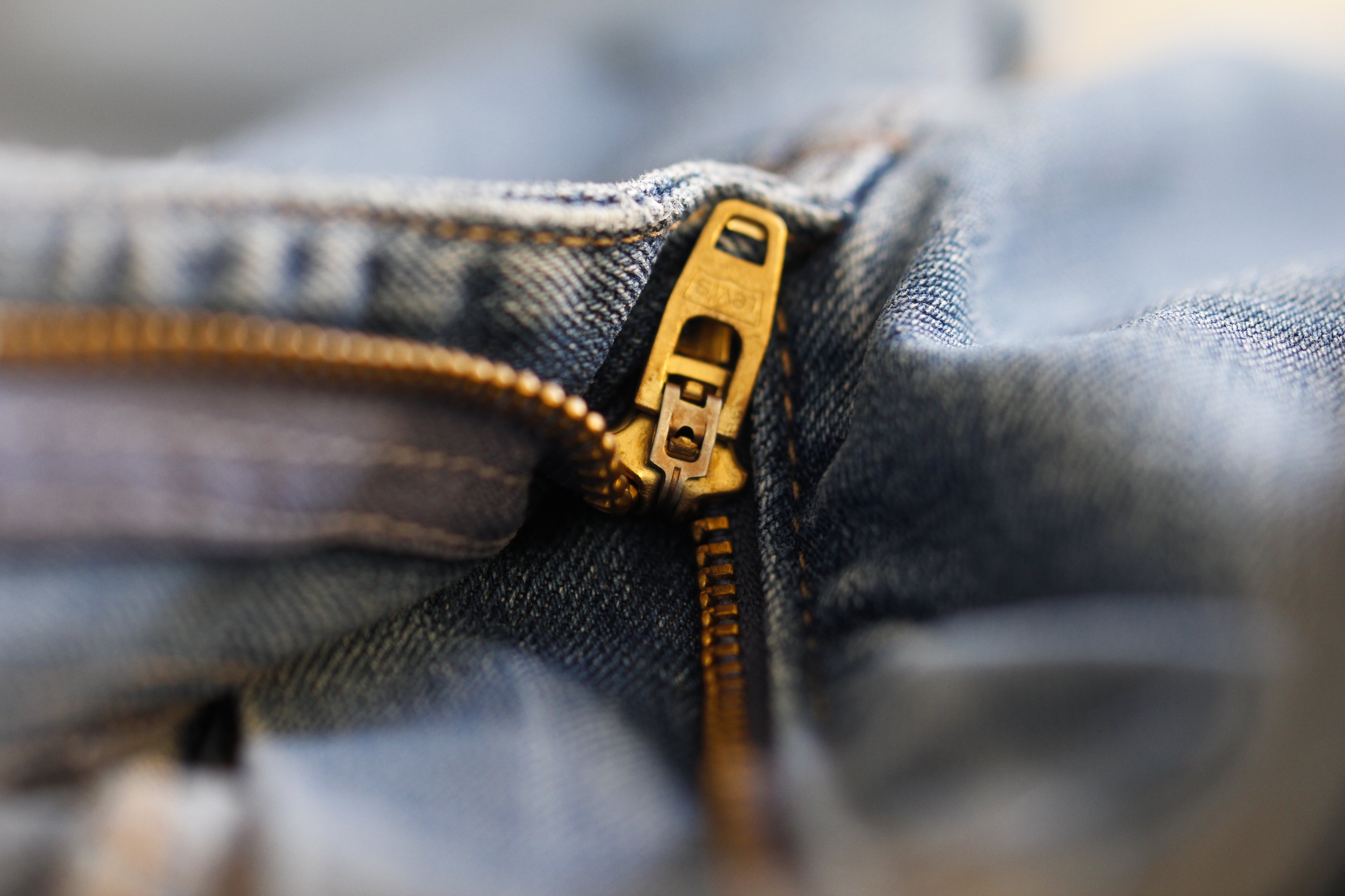 Close up of a gold zipper on blue jeans HD Wallpaper