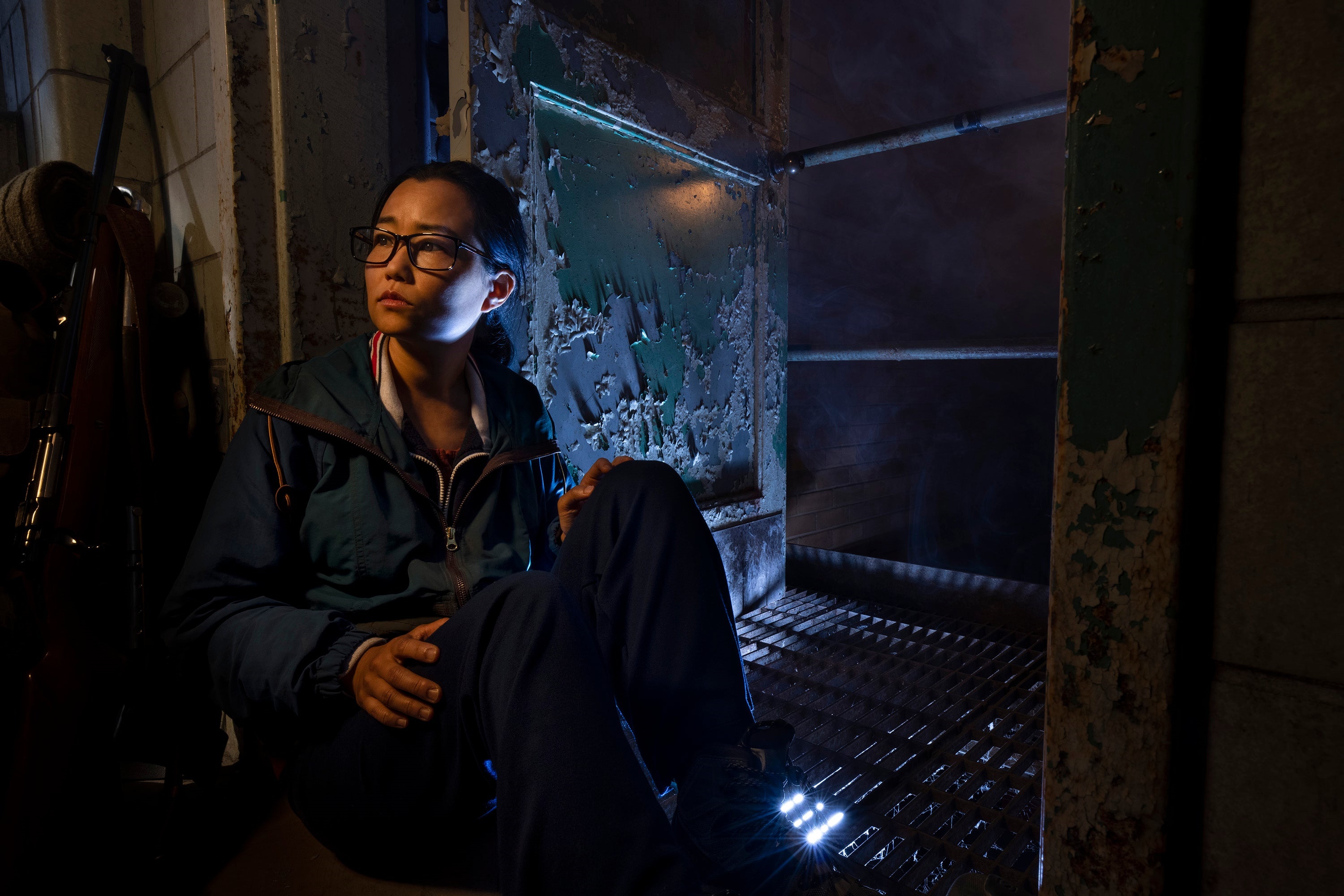 Woman in dark room with peeling paint HD Wallpaper