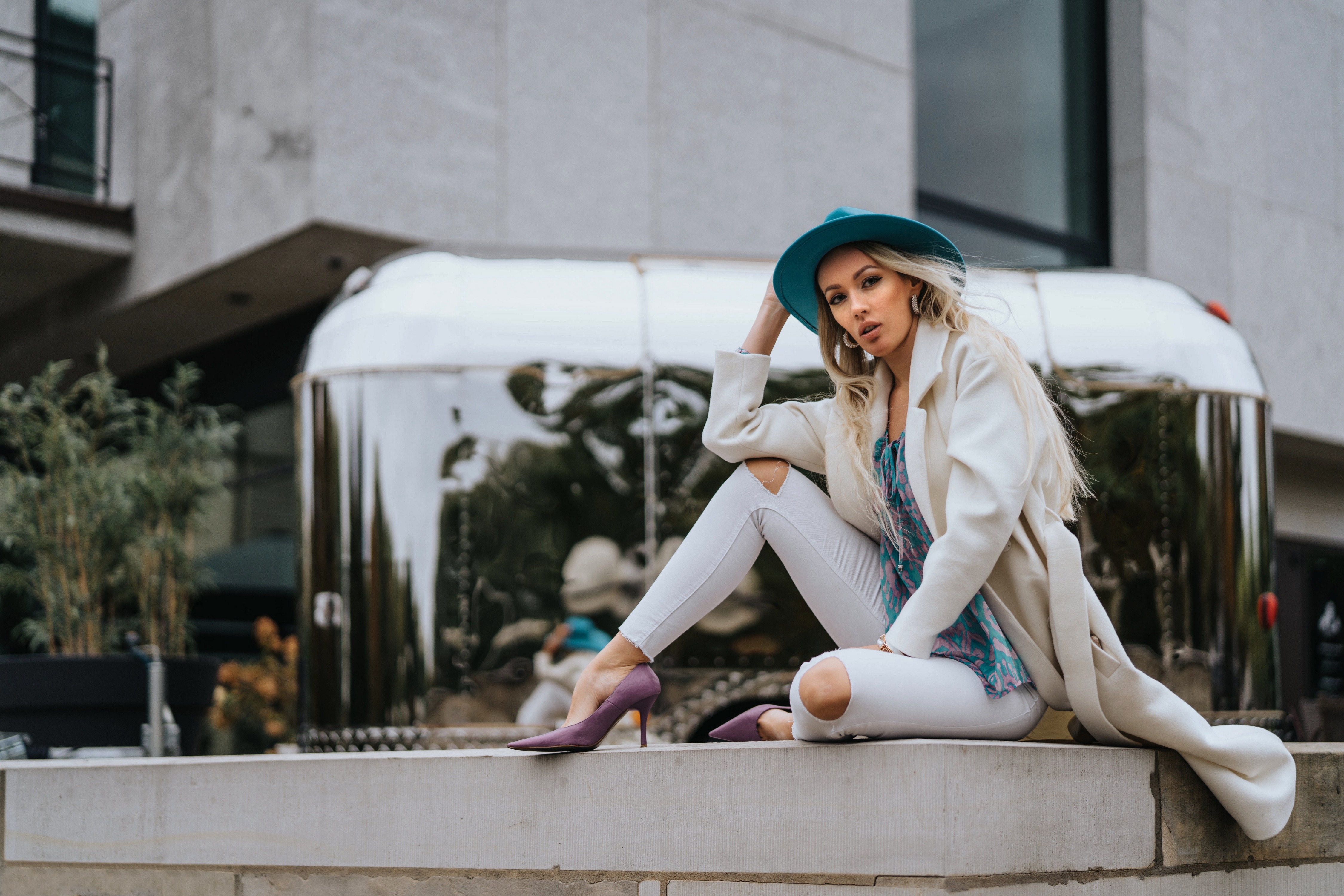 Woman in hat and coat sitting by Airstream HD Wallpaper