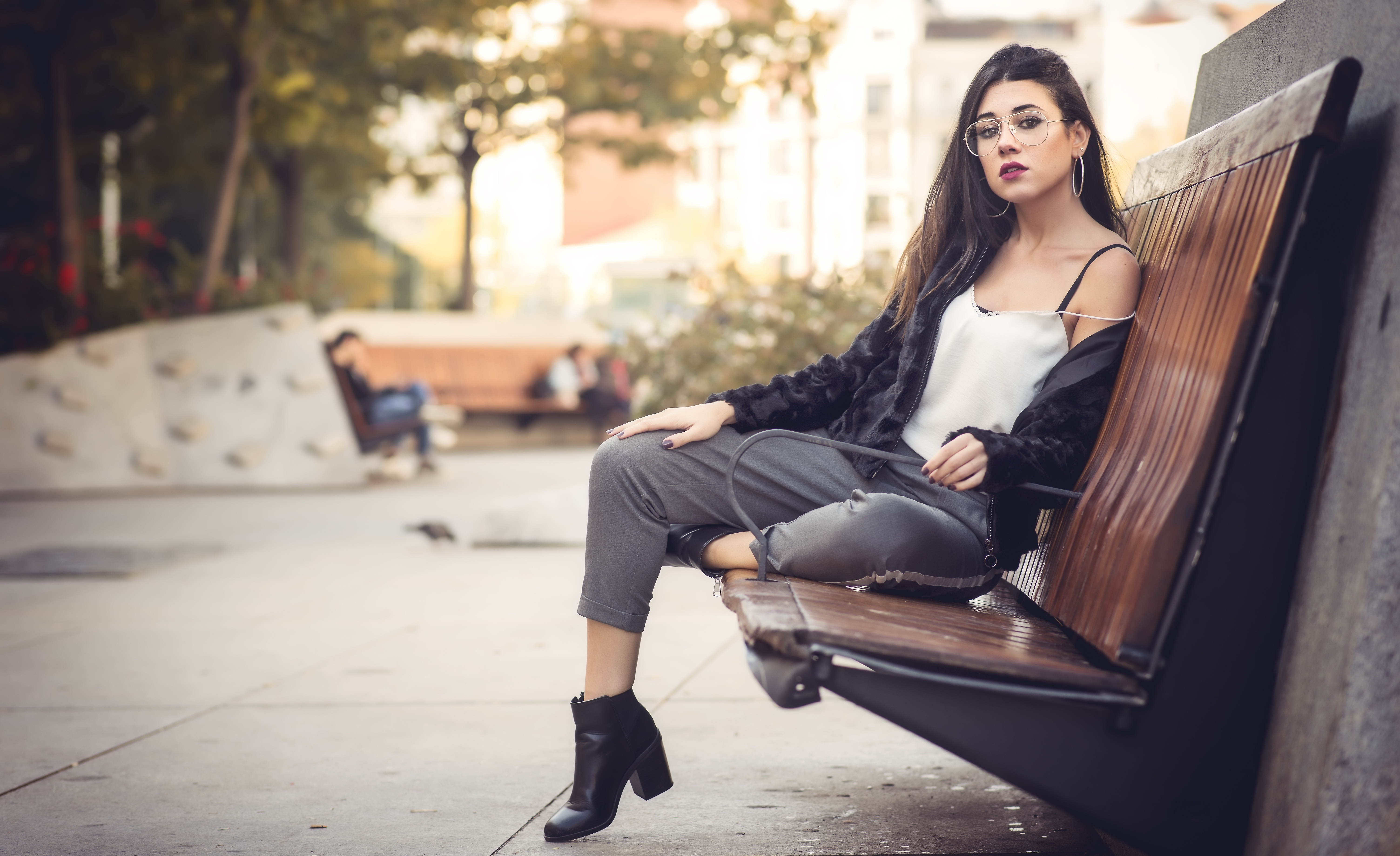 Woman with glasses sitting on a park bench HD Wallpaper