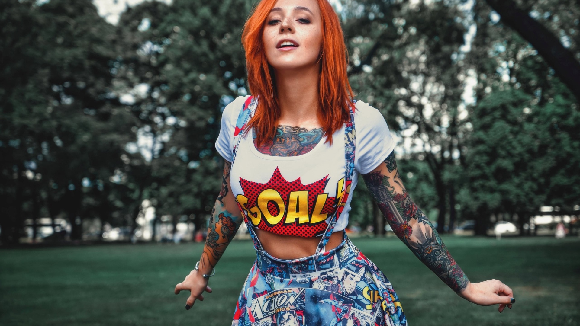 Tattooed redhead woman in comic-themed outfit HD Wallpaper