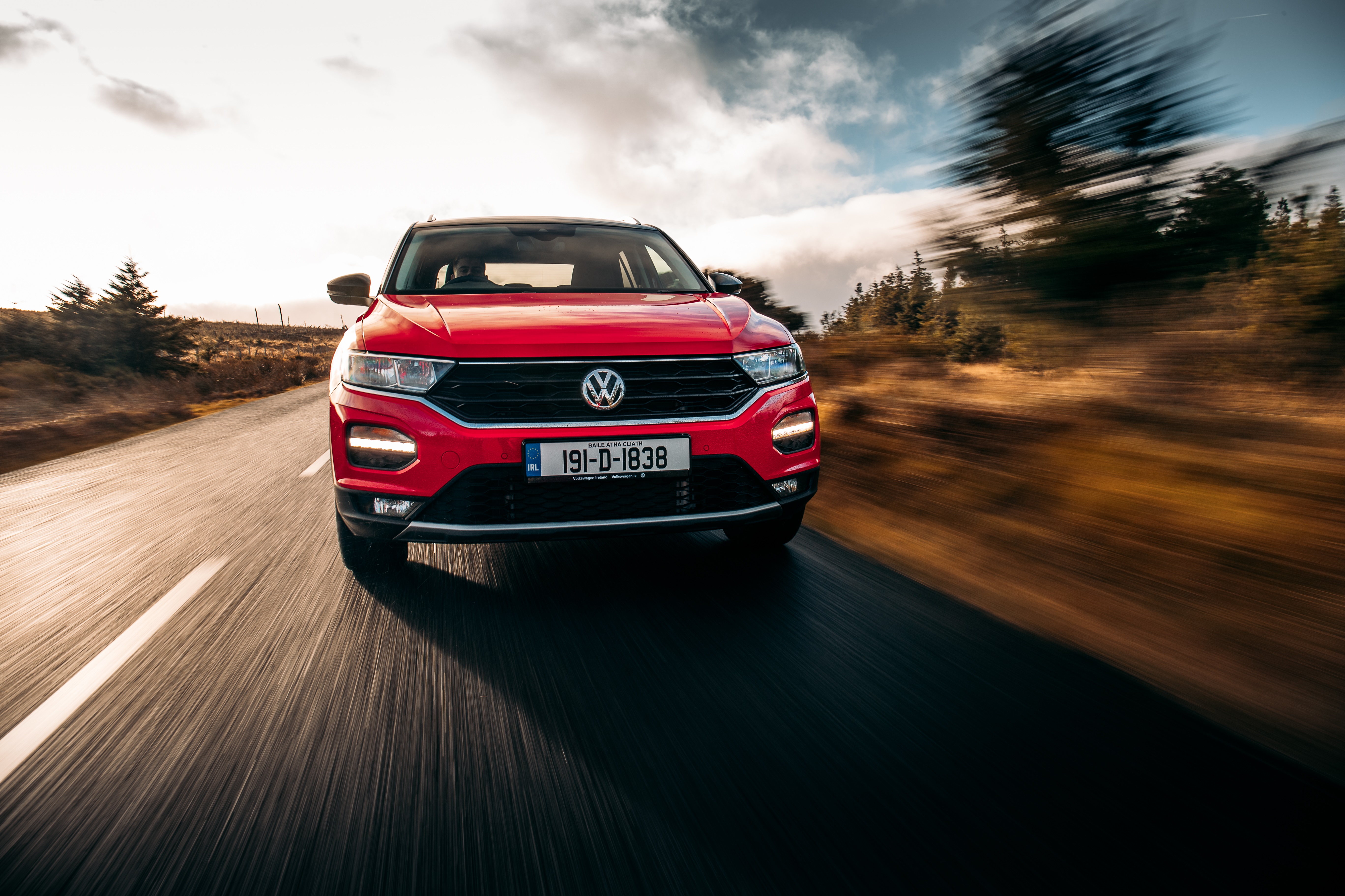 Red Volkswagen T-Roc driving on a road HD Wallpaper