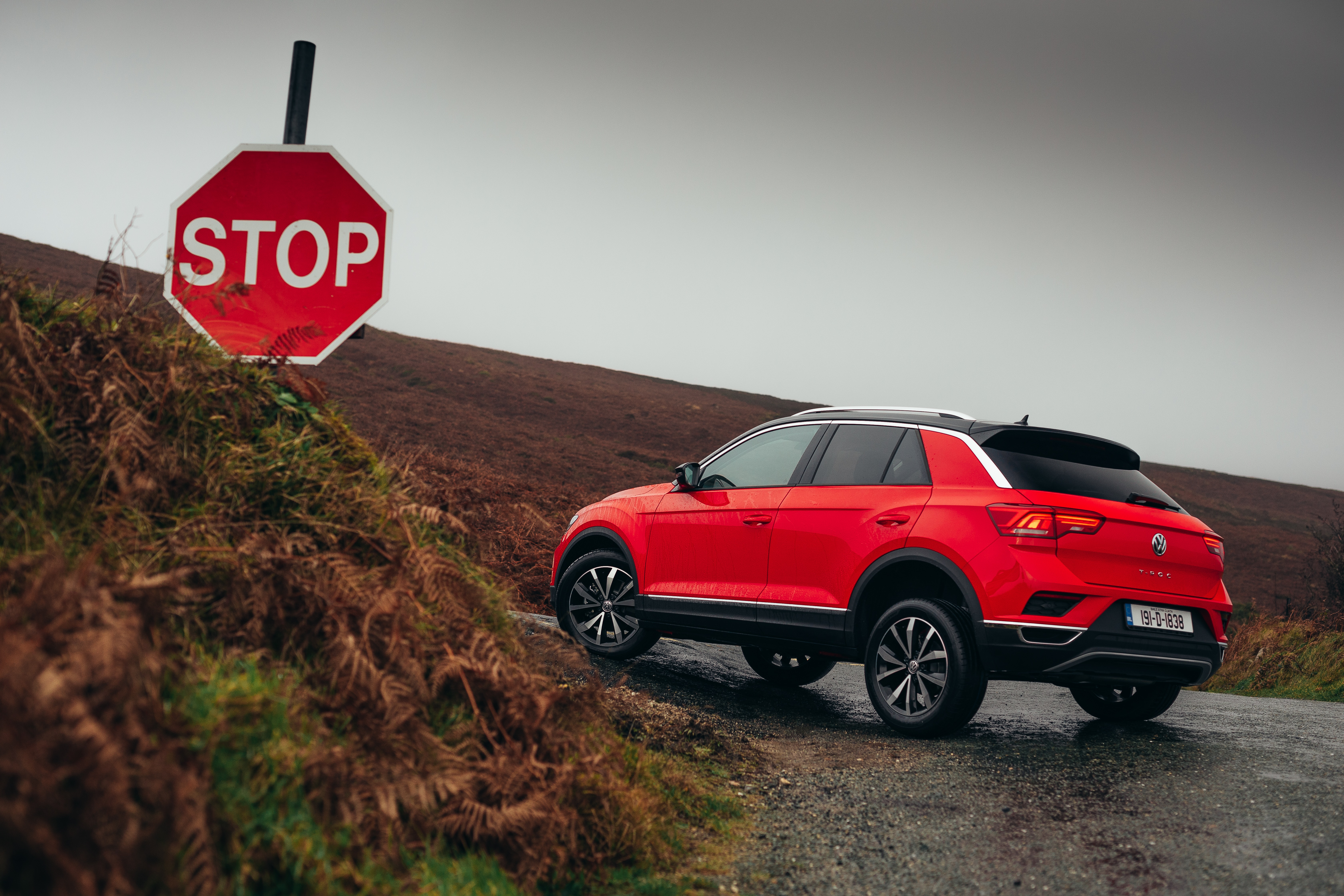 Red Volkswagen T-Roc SUV near stop sign HD Wallpaper