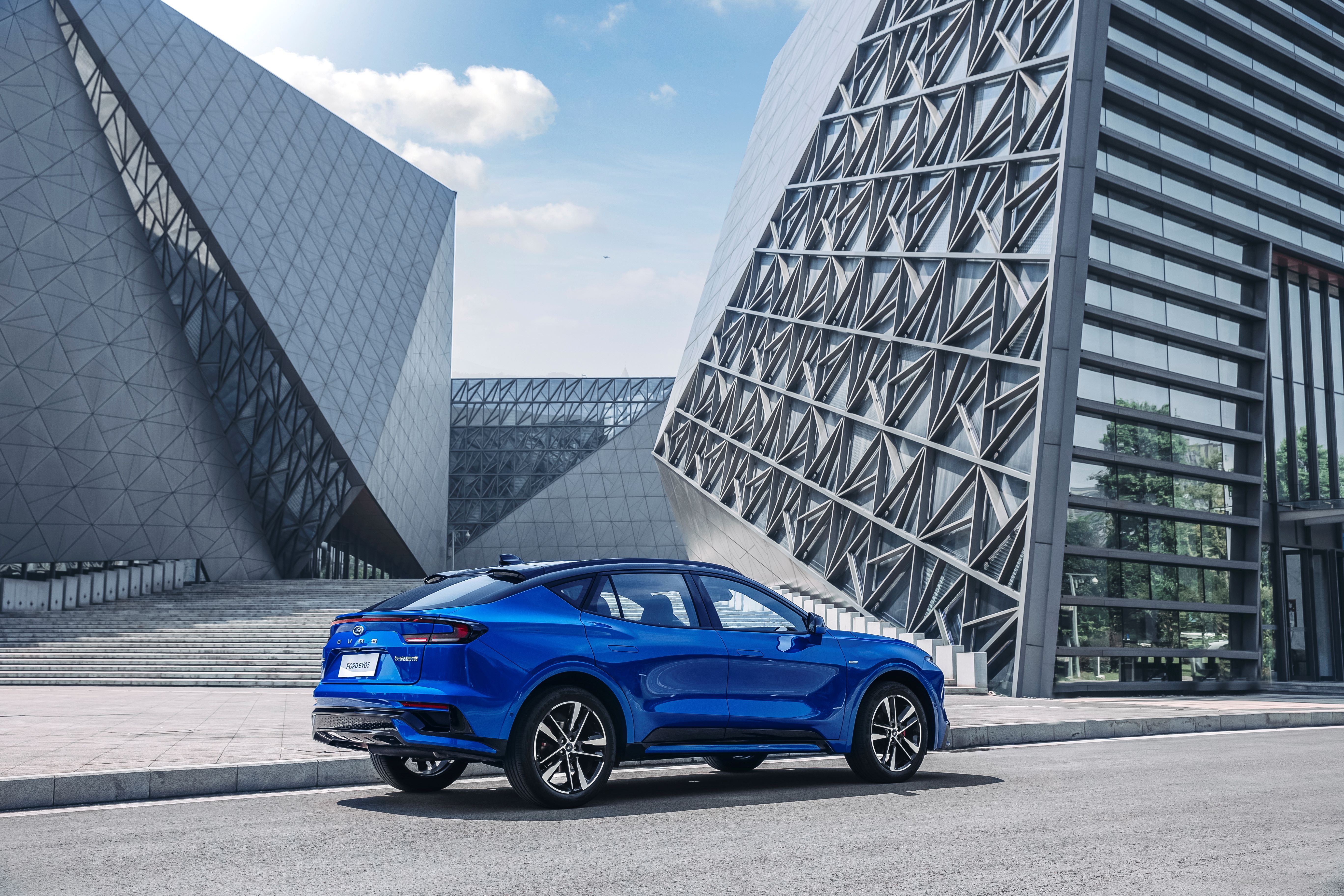 Blue Ford Evos ST-Line SUV parked near modern buildings HD Wallpaper