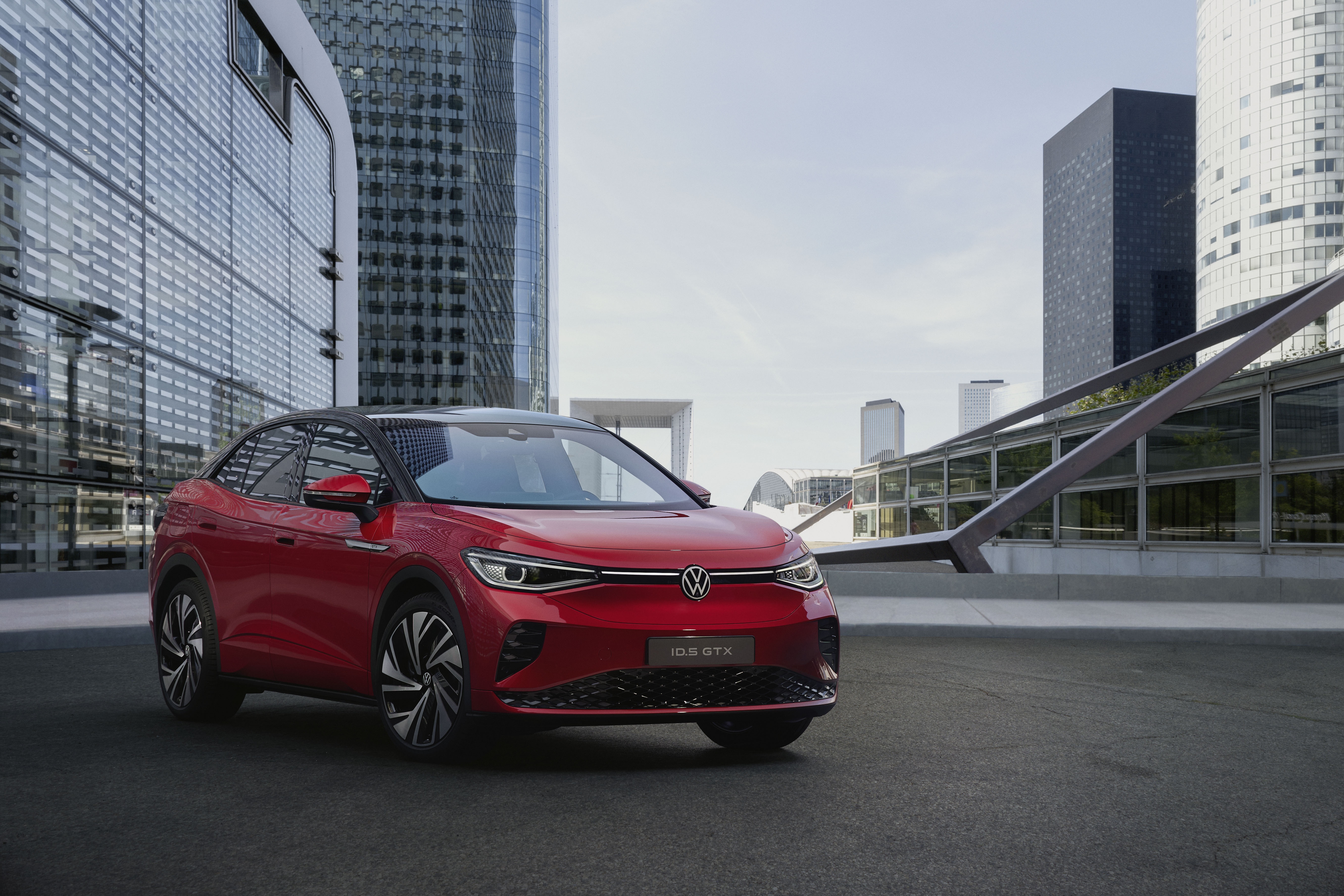 Red Volkswagen ID.5 GTX in modern city HD Wallpaper