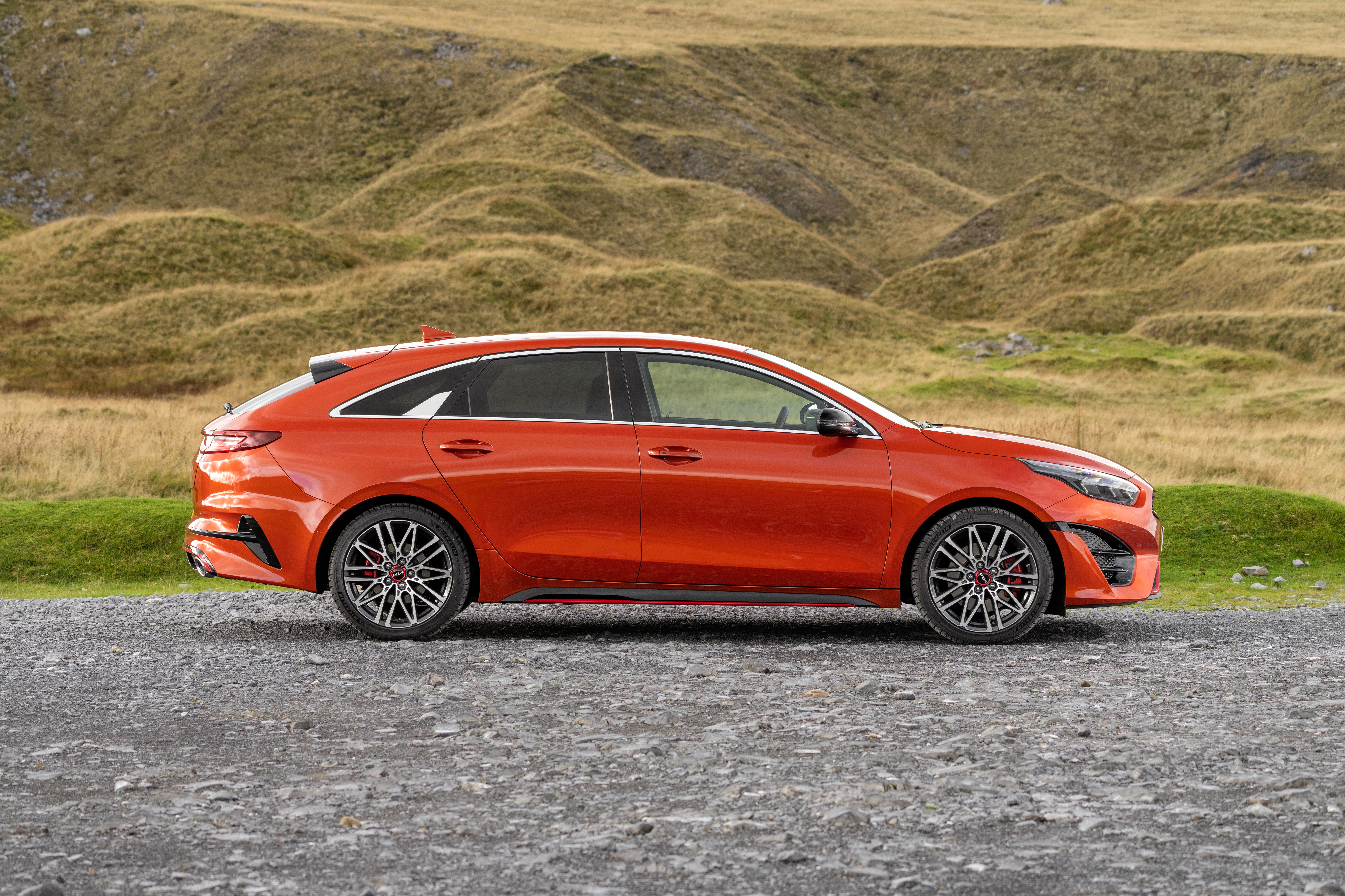 Orange Kia ProCeed GT parked on gravel road HD Wallpaper