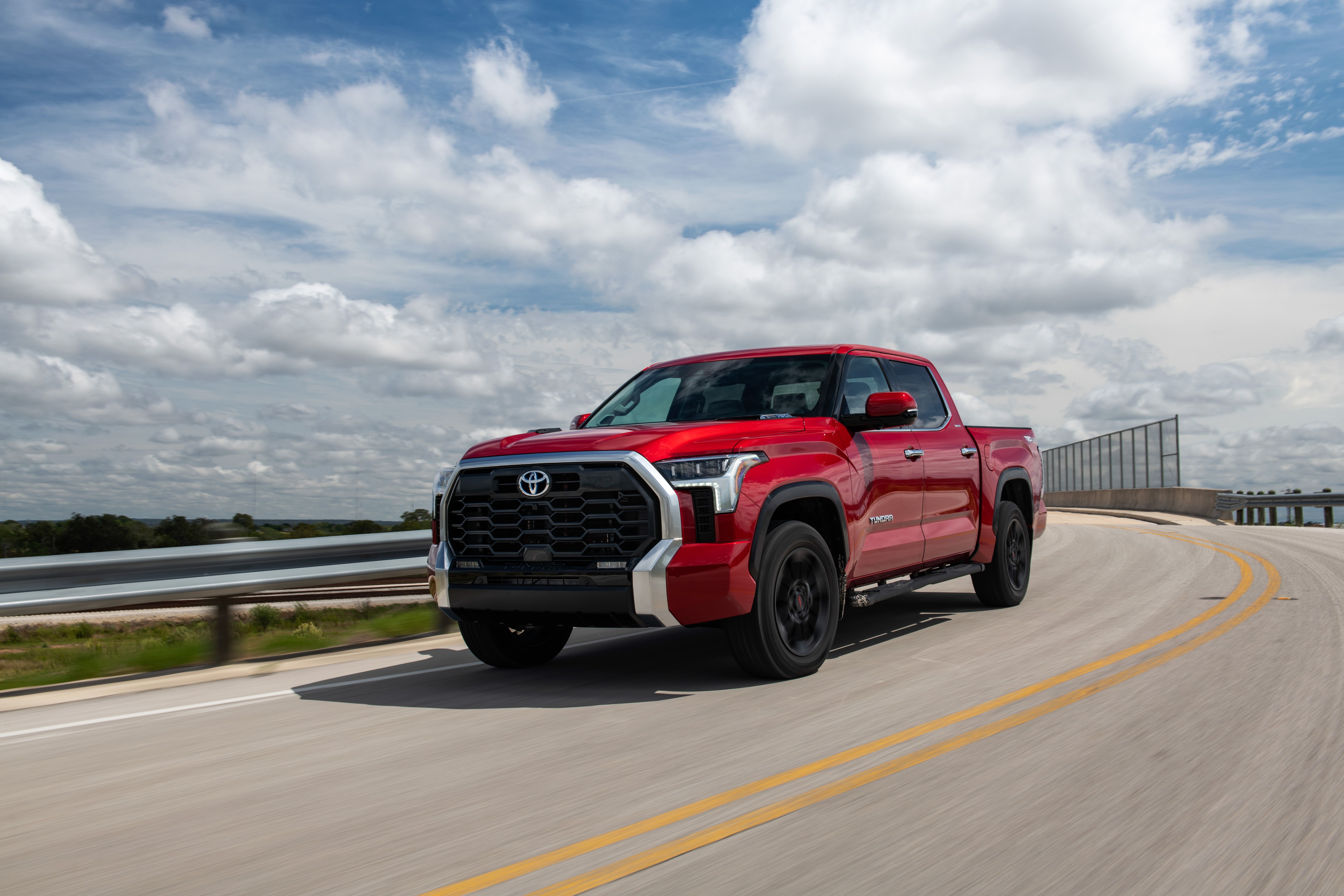 Red Toyota Tundra Limited CrewMax driving on road HD Wallpaper
