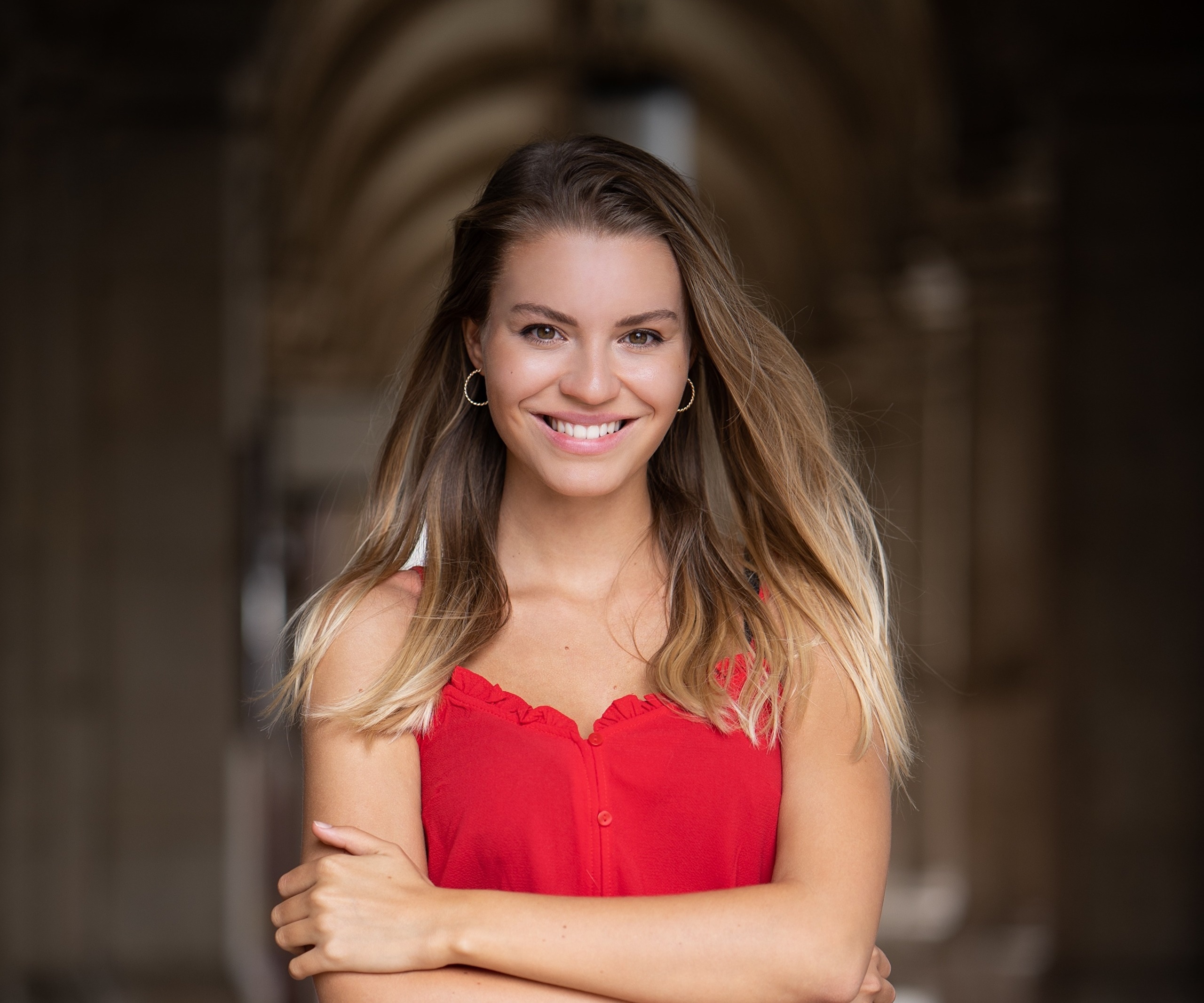 Woman in red top with arms crossed HD Wallpaper