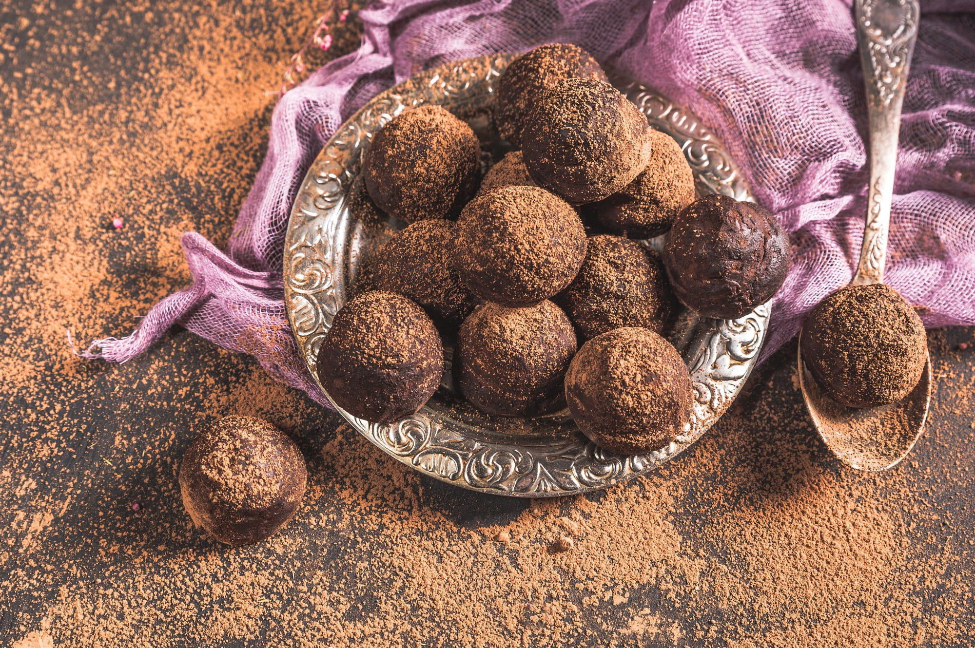 Chocolate truffles dusted with cocoa powder on a silver plate HD Wallpaper