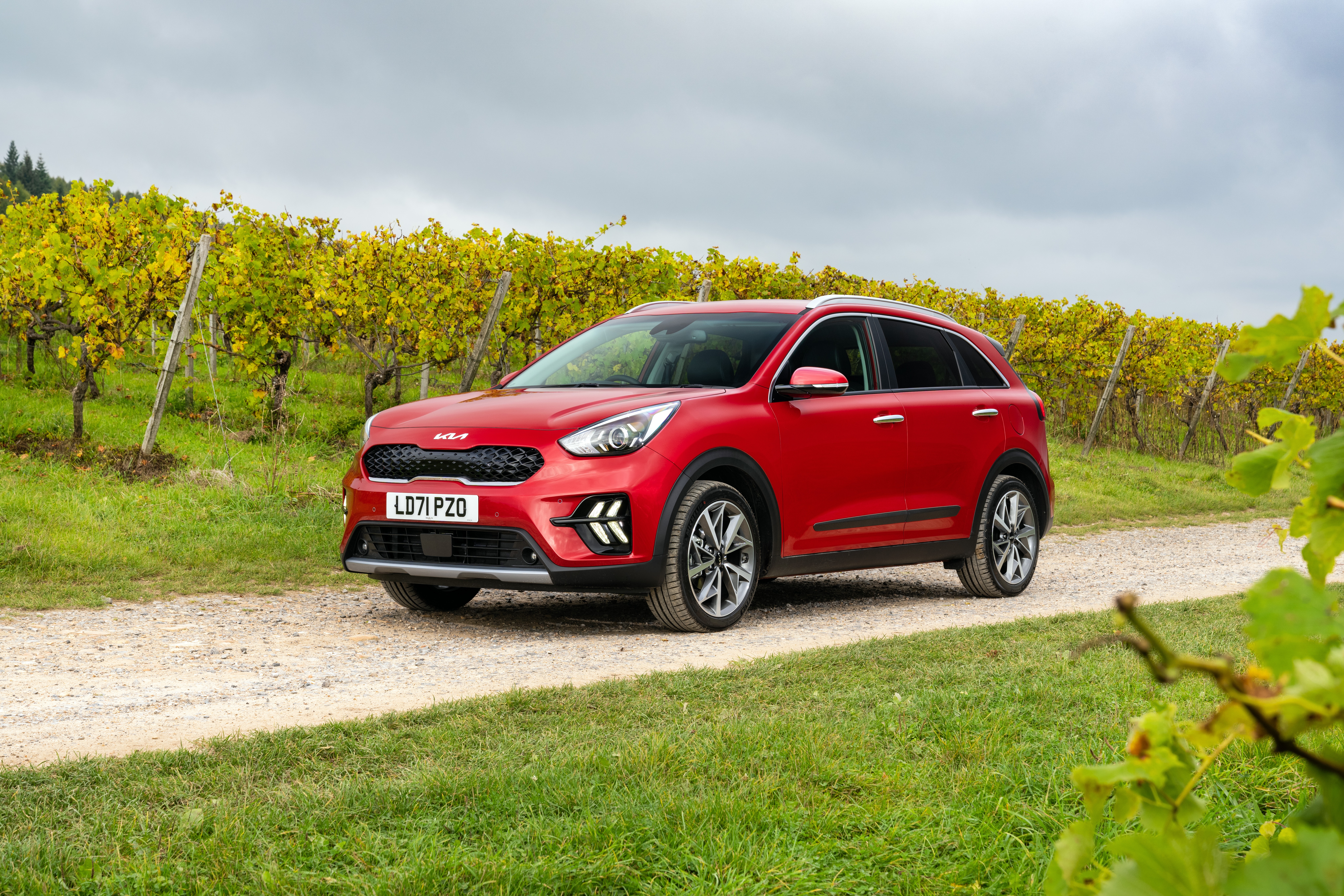 Red Kia Niro EcoHybrid SUV on a dirt road HD Wallpaper