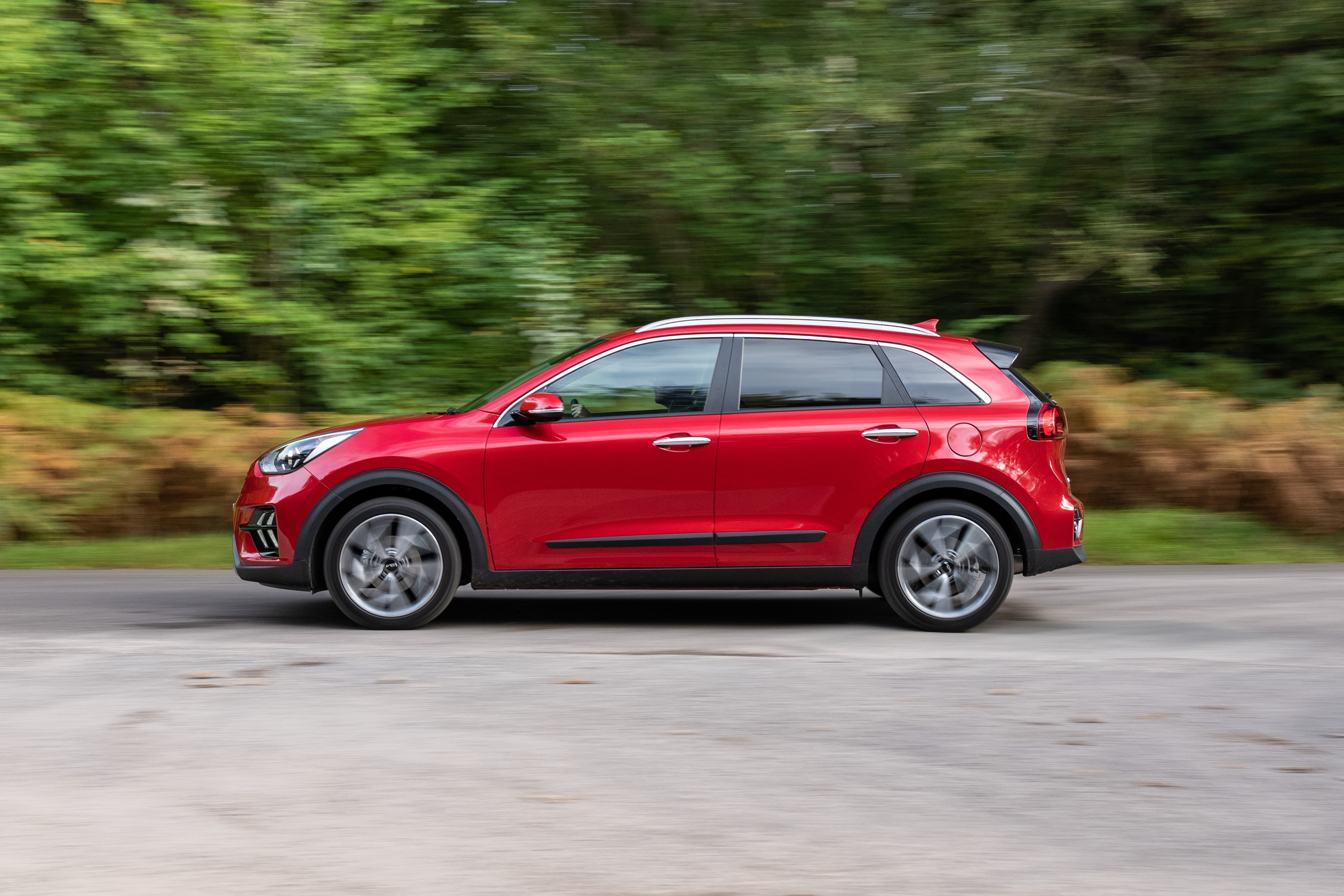 Red Kia Niro EcoHybrid SUV driving on a road HD Wallpaper