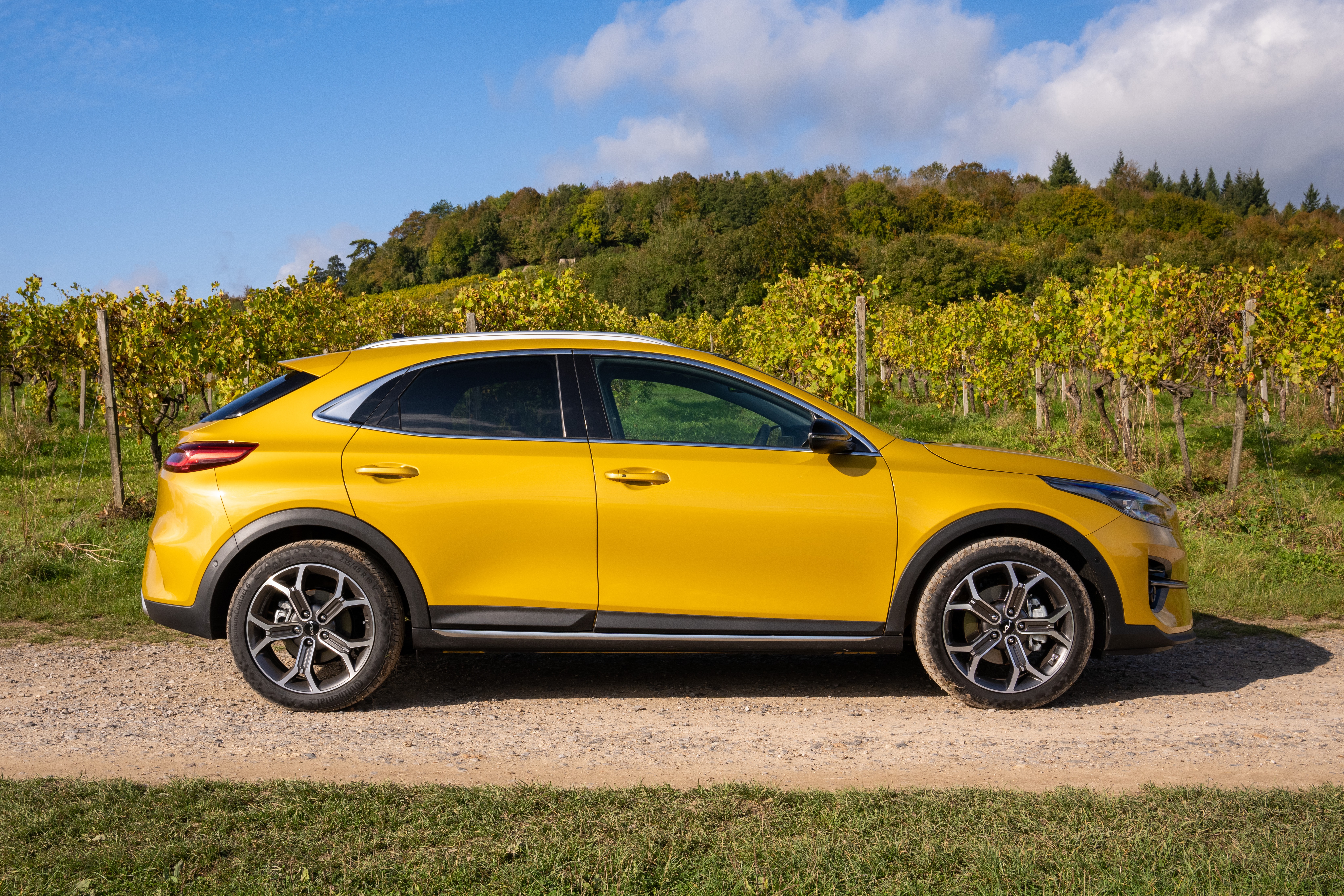Yellow Kia XCeed SUV parked on a dirt road HD Wallpaper