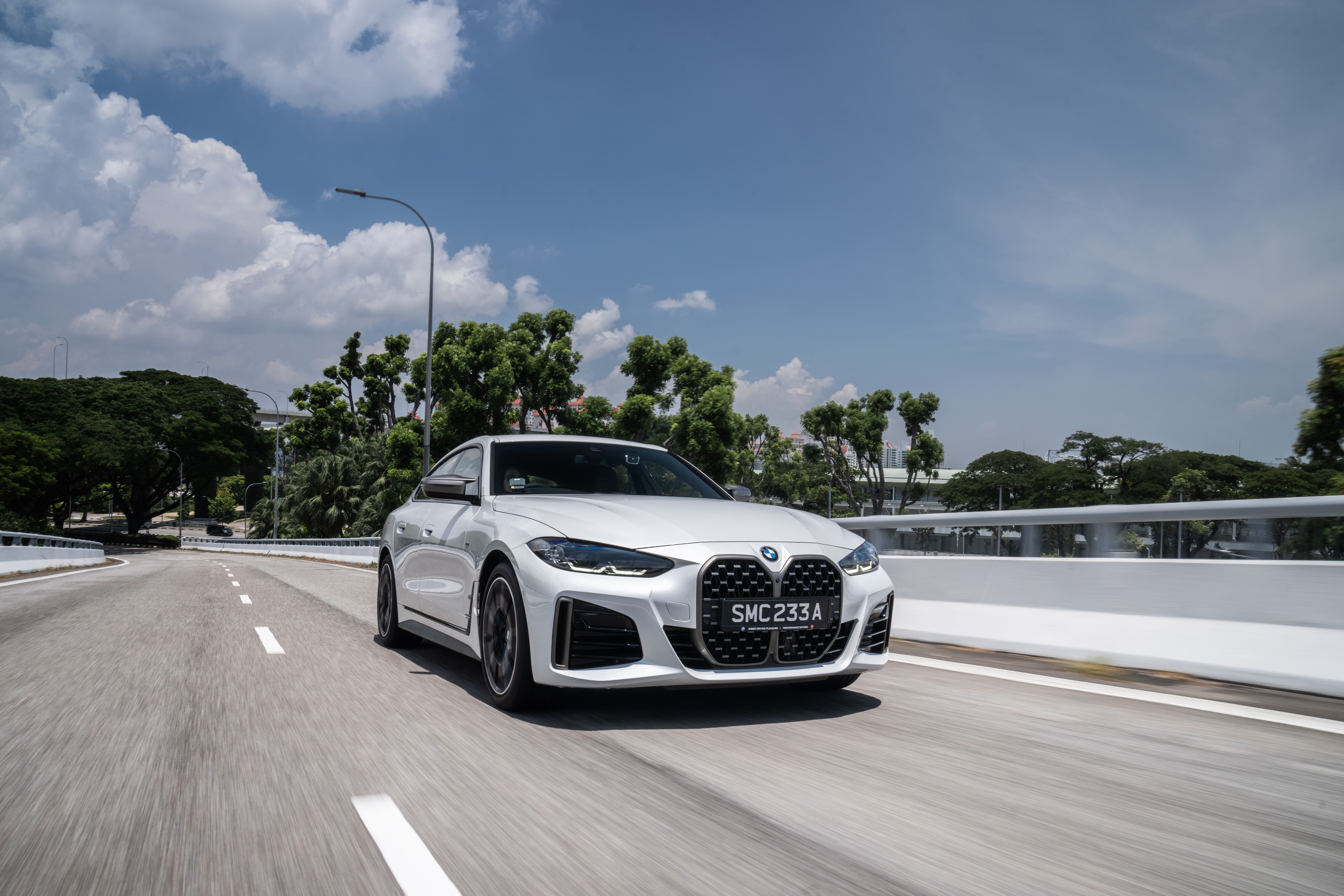 White BMW M440i xDrive Gran Coupé driving on a road HD Wallpaper