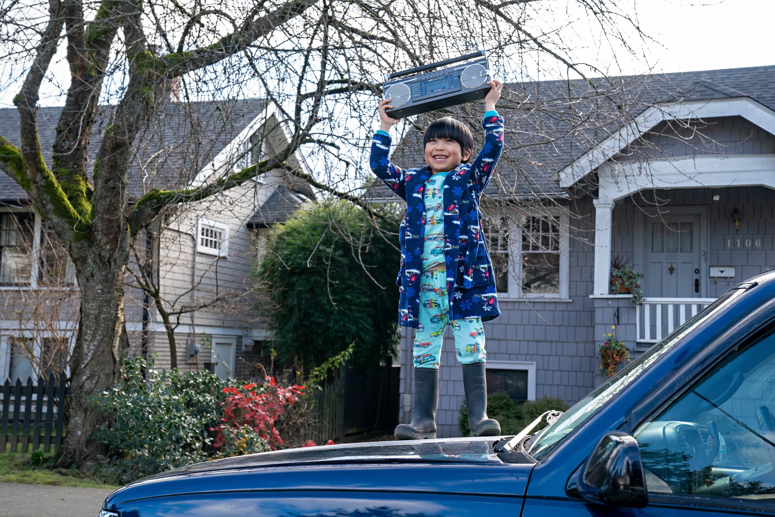 Young boy holding a boombox on a car HD Wallpaper