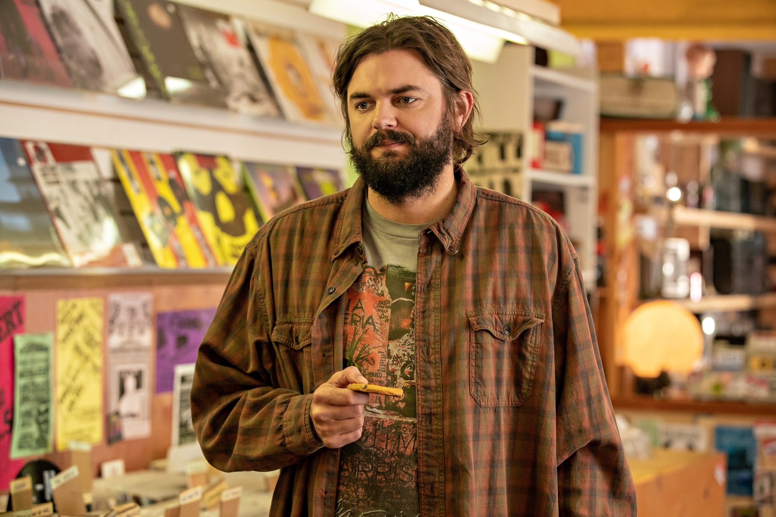 Man holding a cigarette in a record store HD Wallpaper