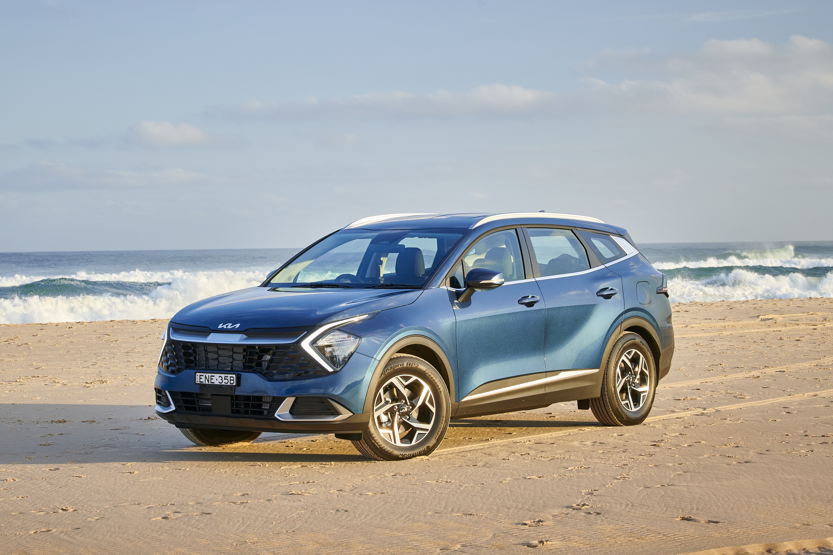 Blue Kia Sportage SUV on a beach HD Wallpaper