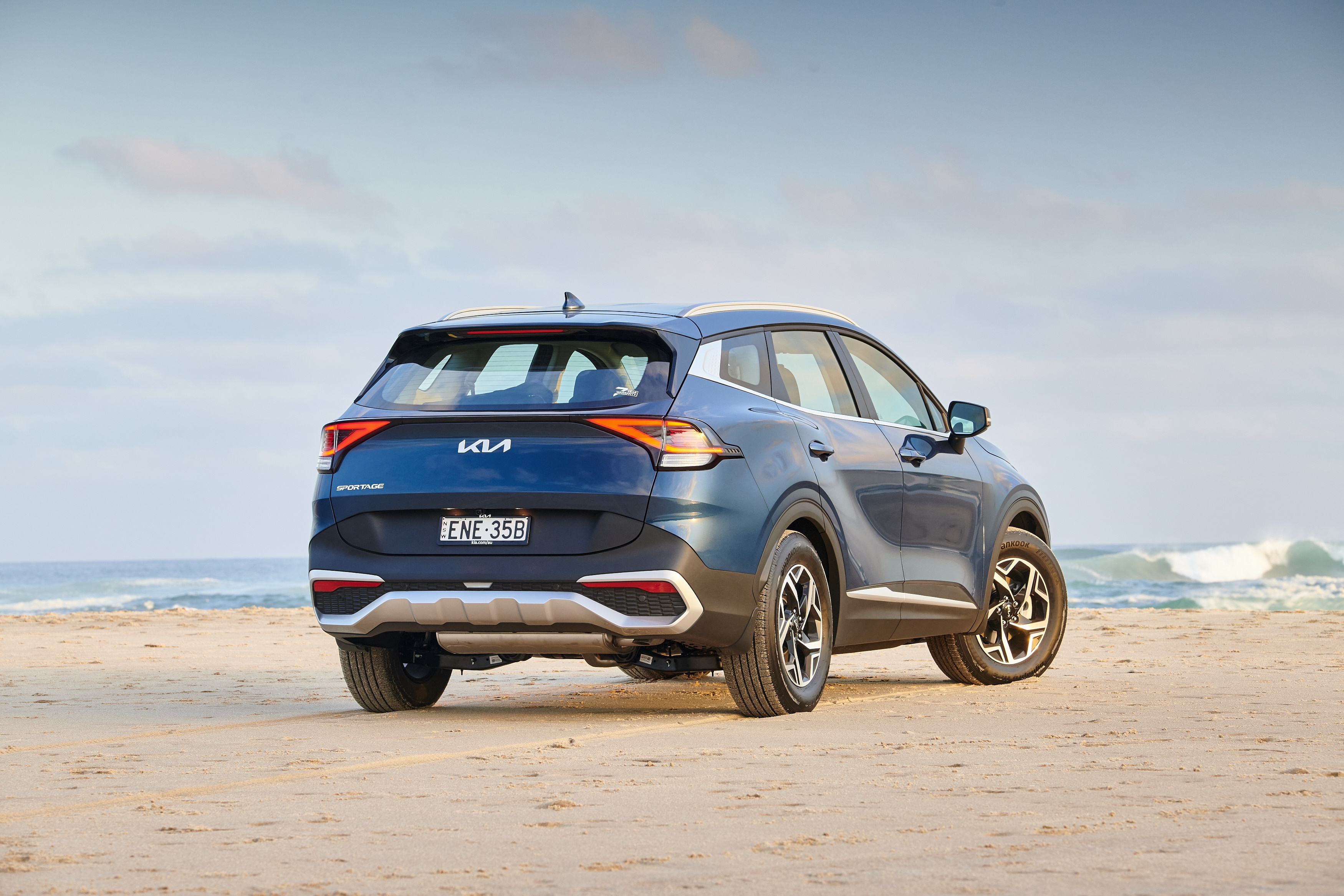 Blue Kia Sportage SUV on a sandy beach HD Wallpaper
