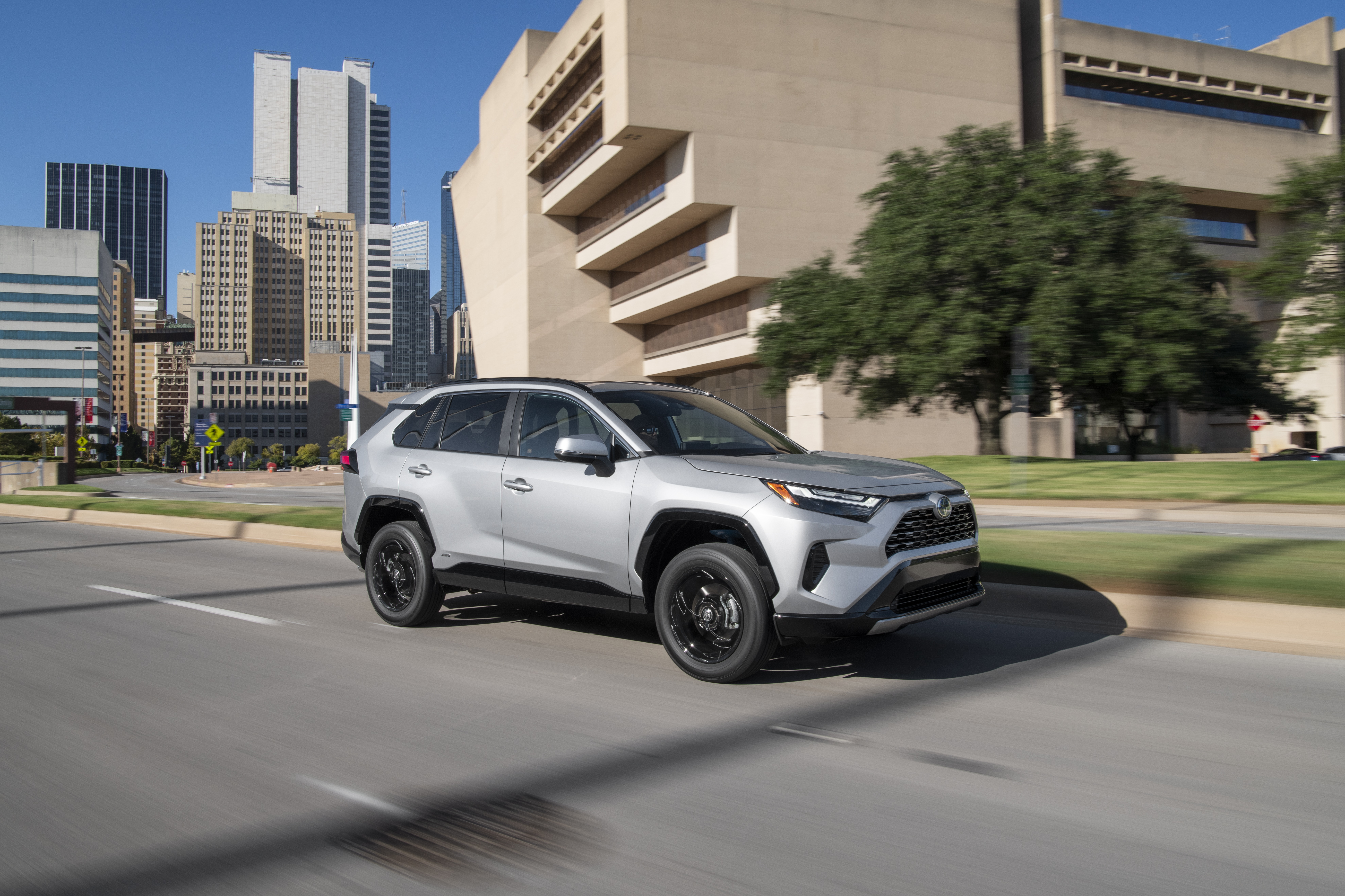 Silver Toyota RAV4 SE Hybrid driving in city HD Wallpaper