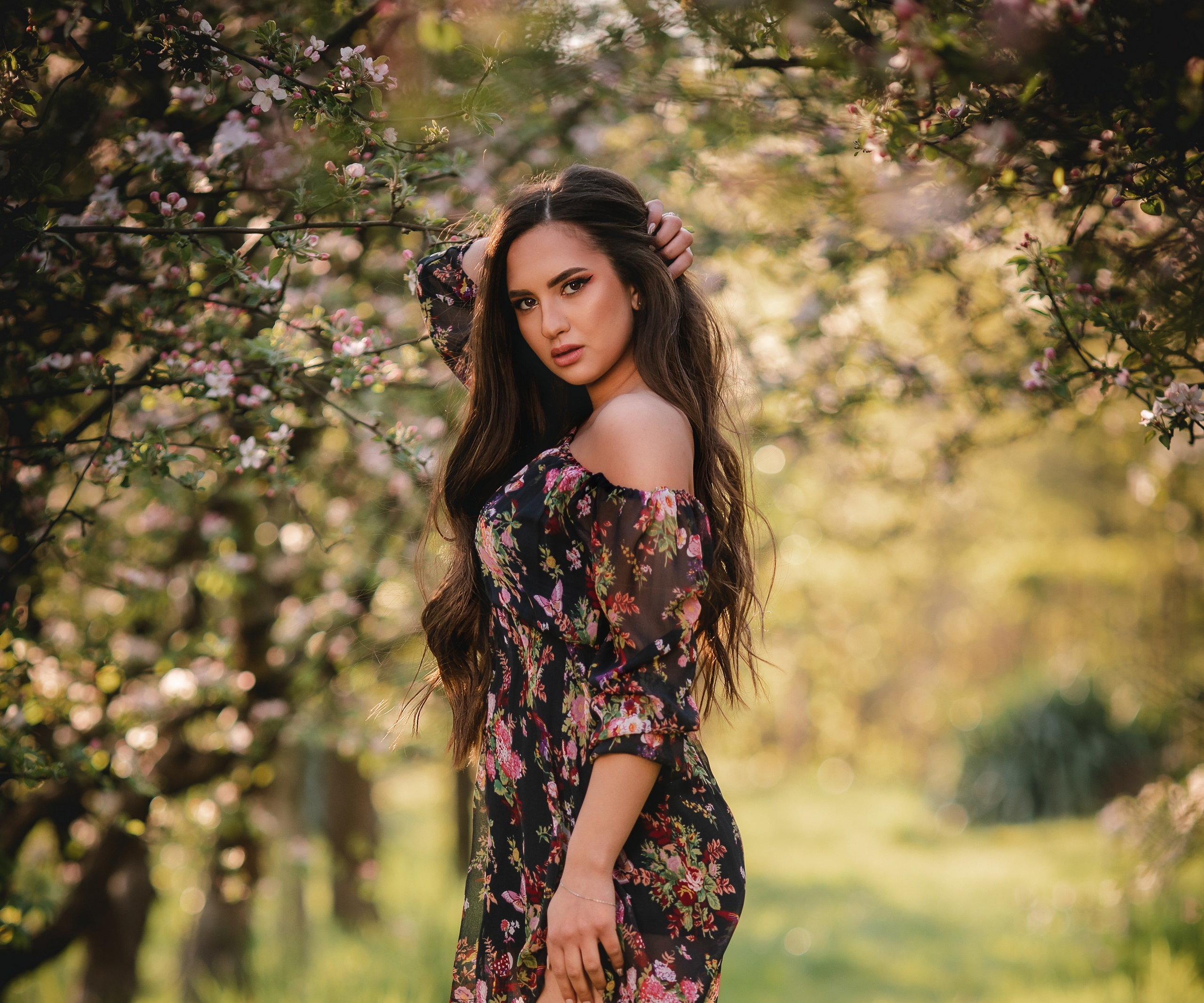 Brunette woman in floral dress in orchard HD Wallpaper