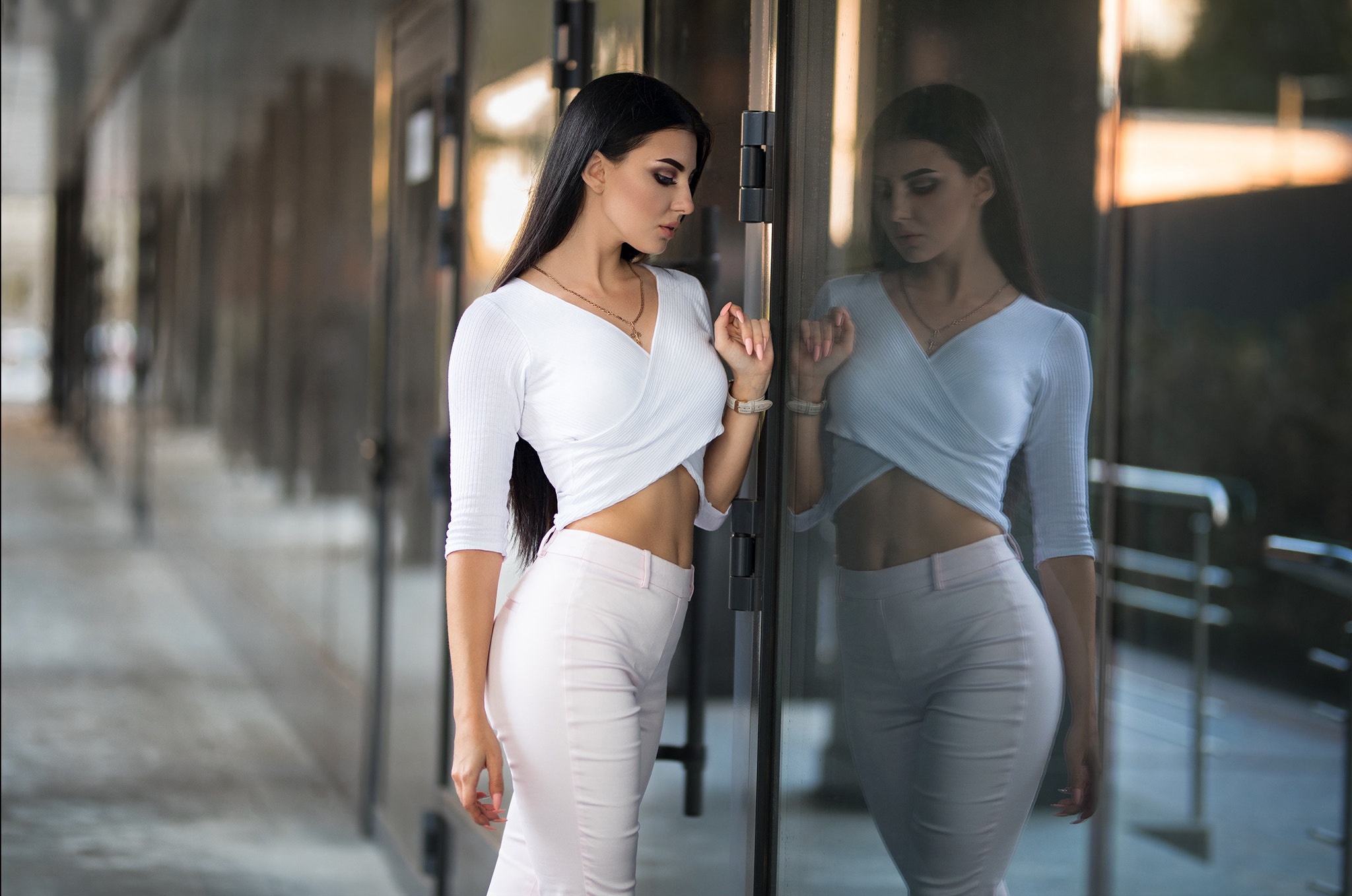 Woman in white top and pink pants reflected in glass HD Wallpaper