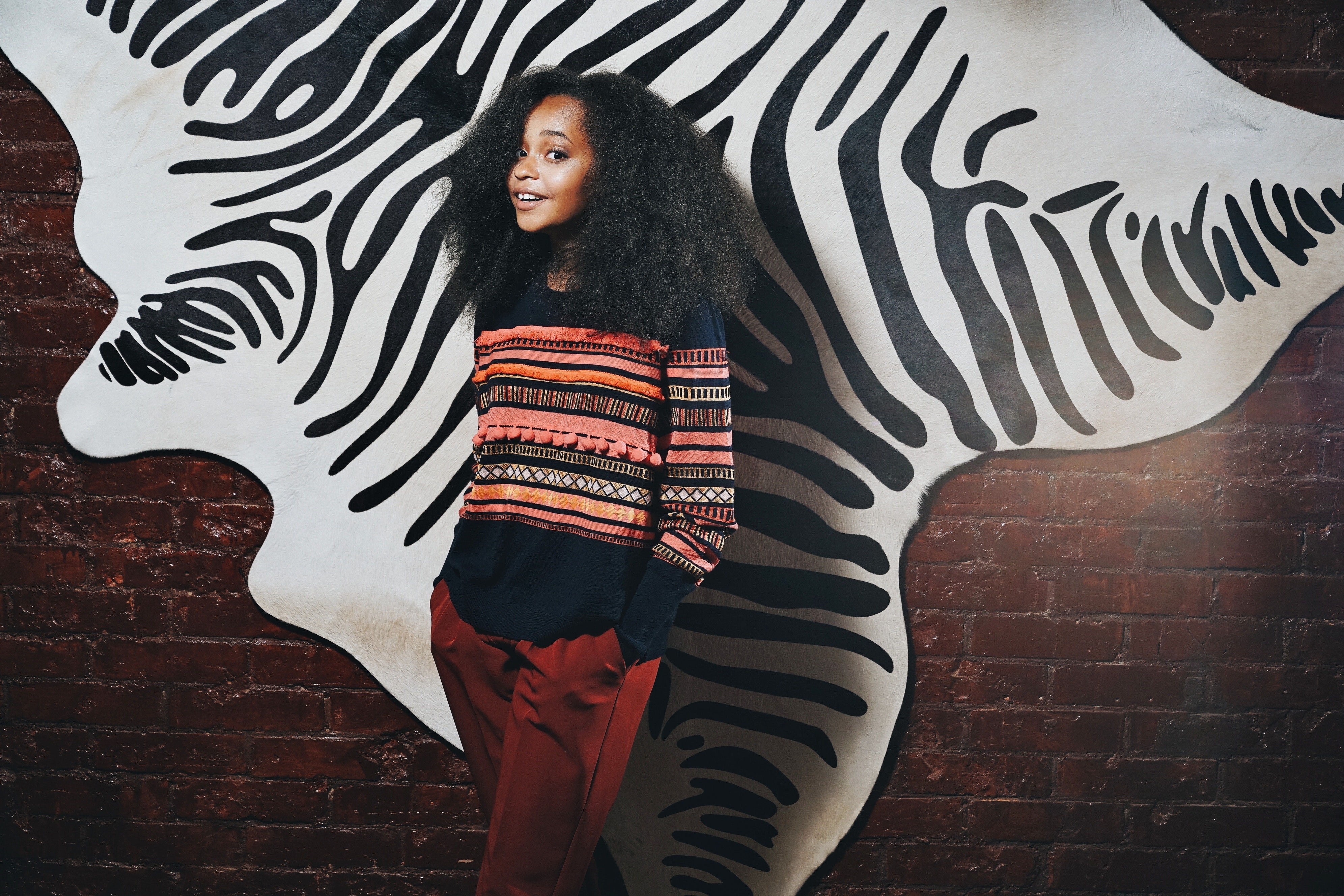 Young girl with black hair in colorful sweater HD Wallpaper