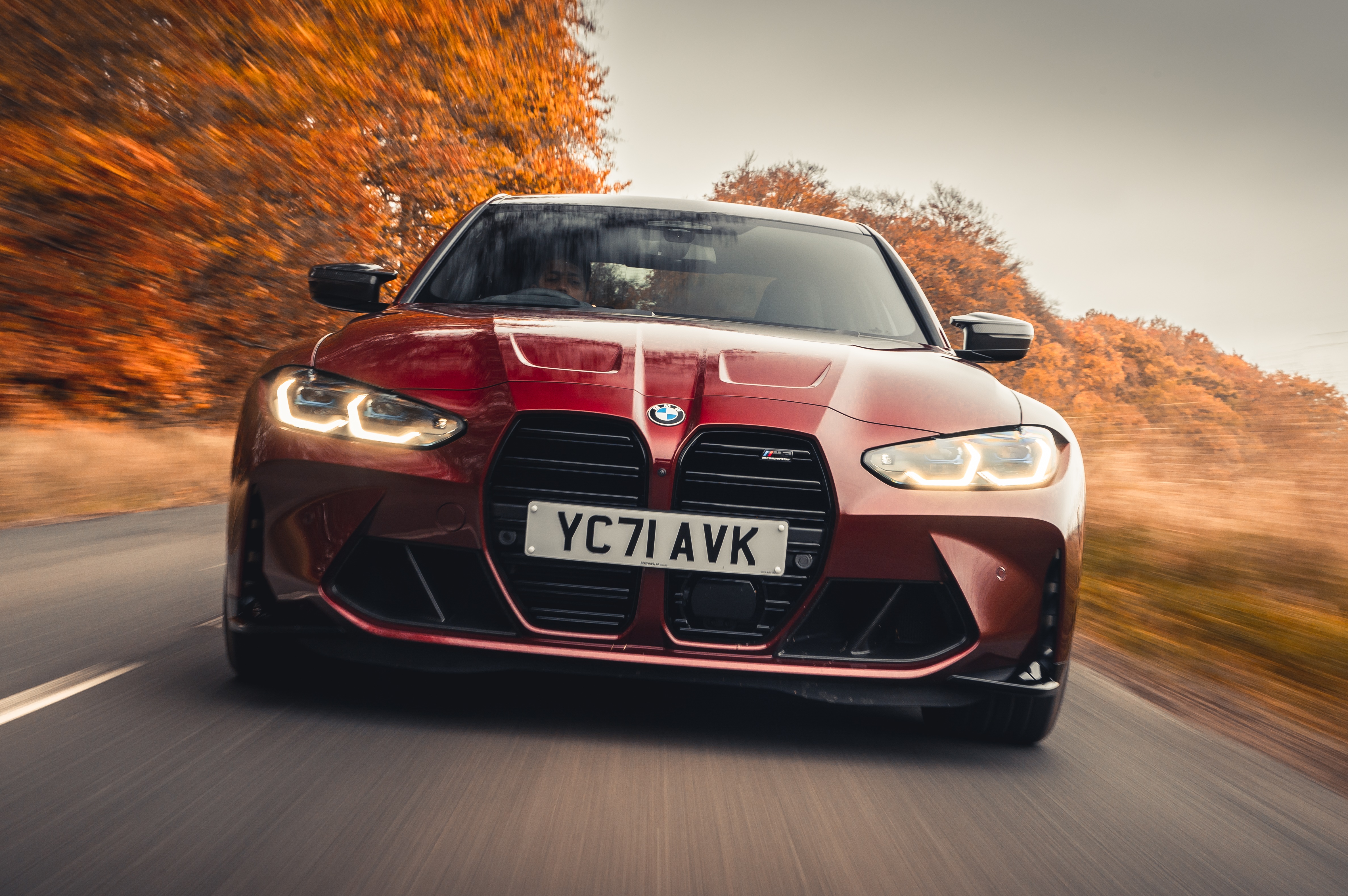 Red BMW M3 Competition driving on a road HD Wallpaper