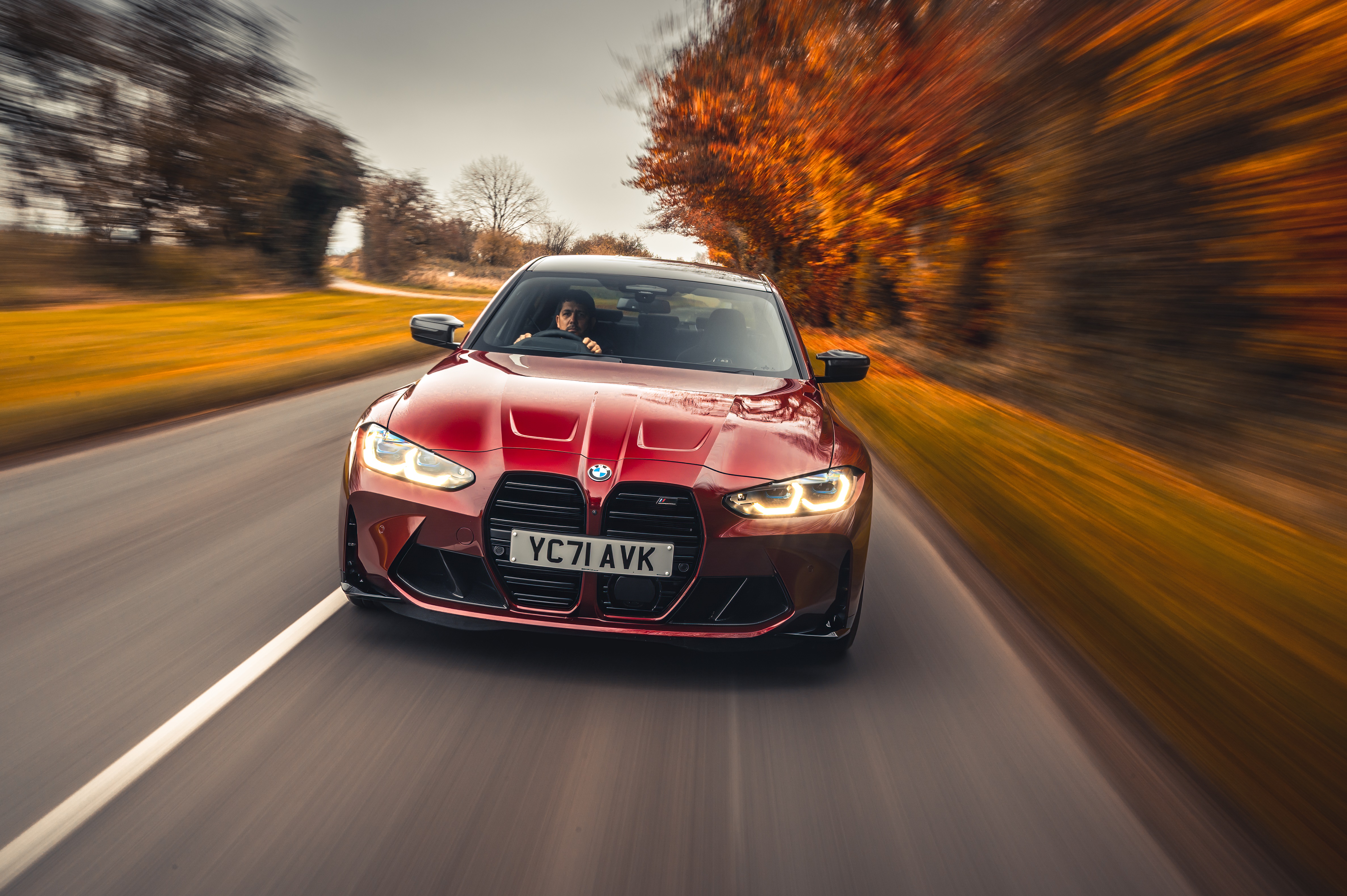 Red BMW M3 Competition driving on a road HD Wallpaper