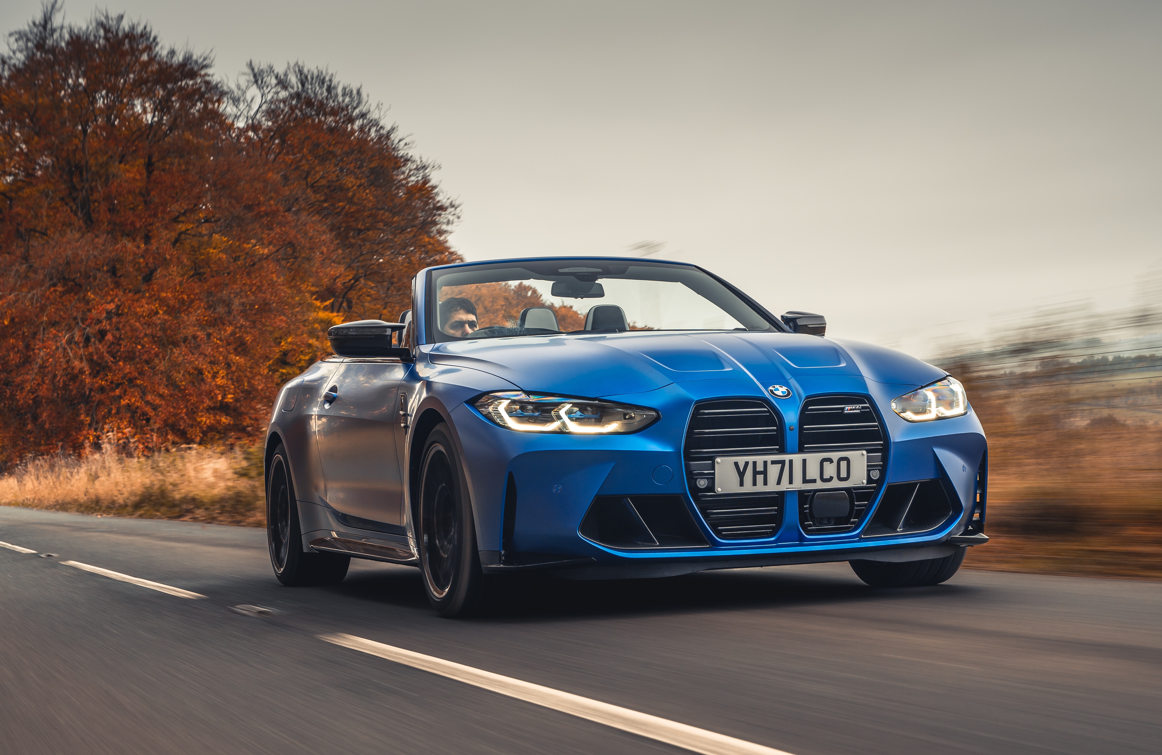 Blue BMW M4 Competition Convertible driving on road HD Wallpaper