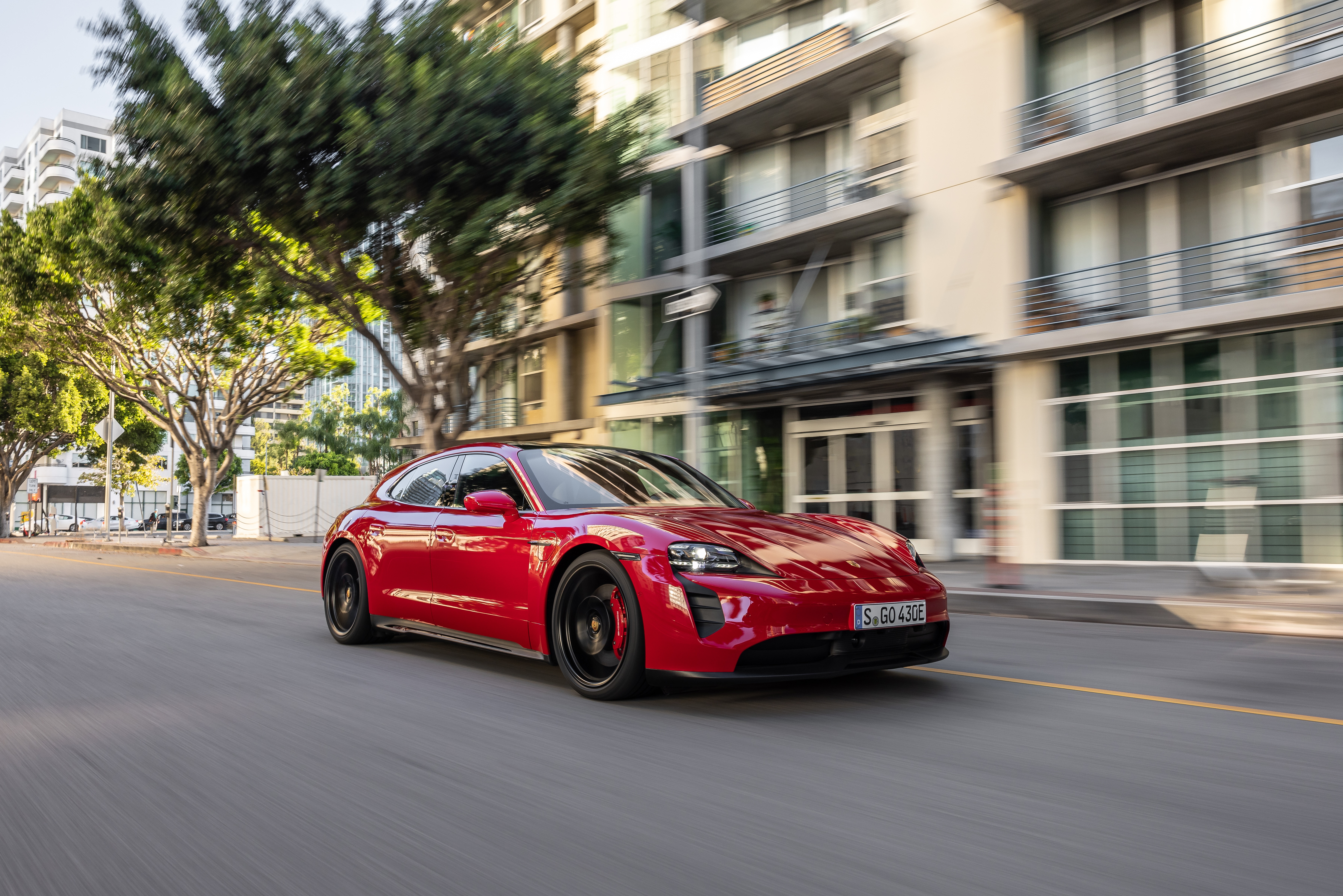 Red Porsche Taycan GTS Sport Turismo driving on street HD Wallpaper