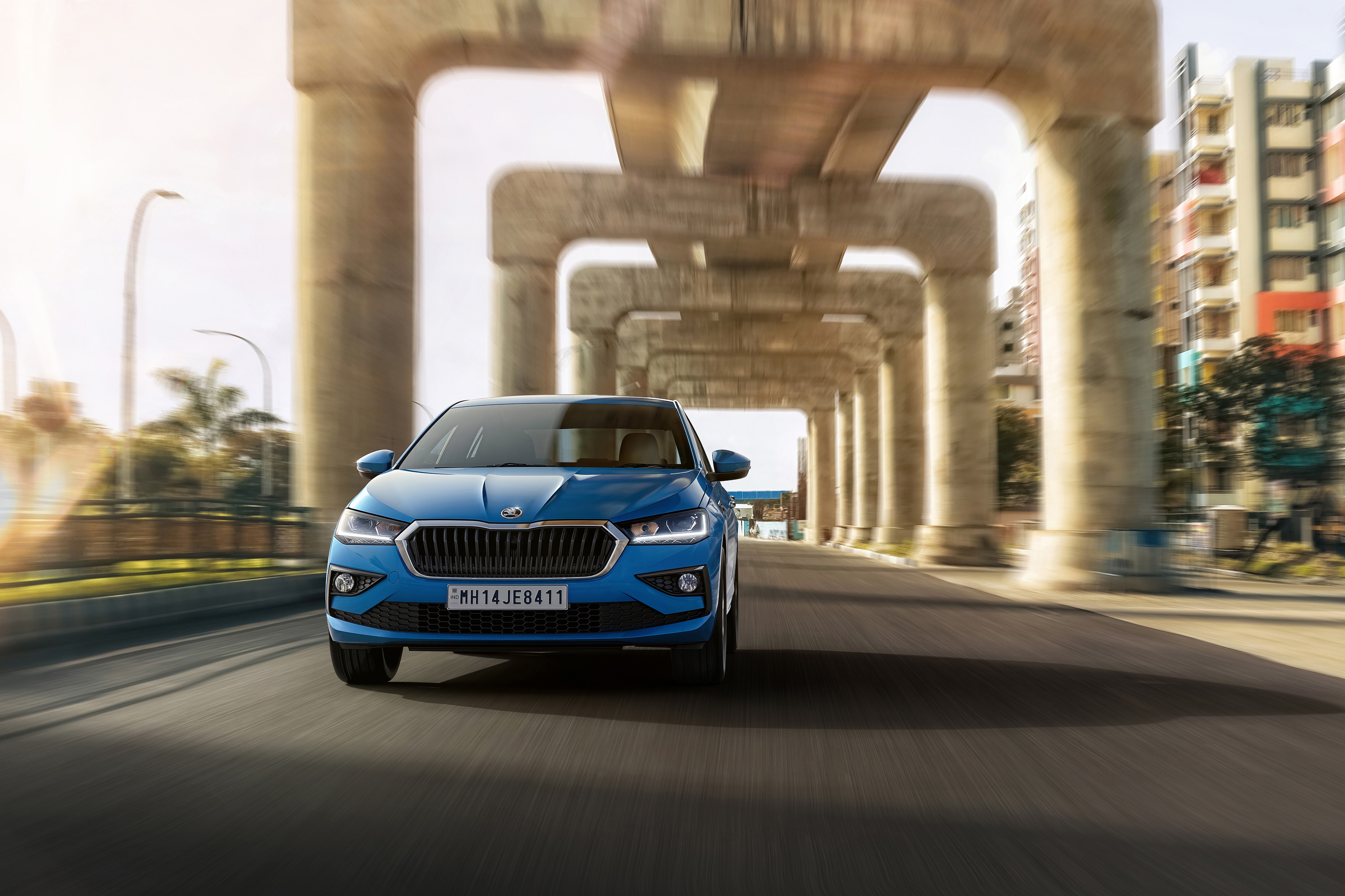 Blue Skoda Slavia 4K driving under concrete overpass HD Wallpaper