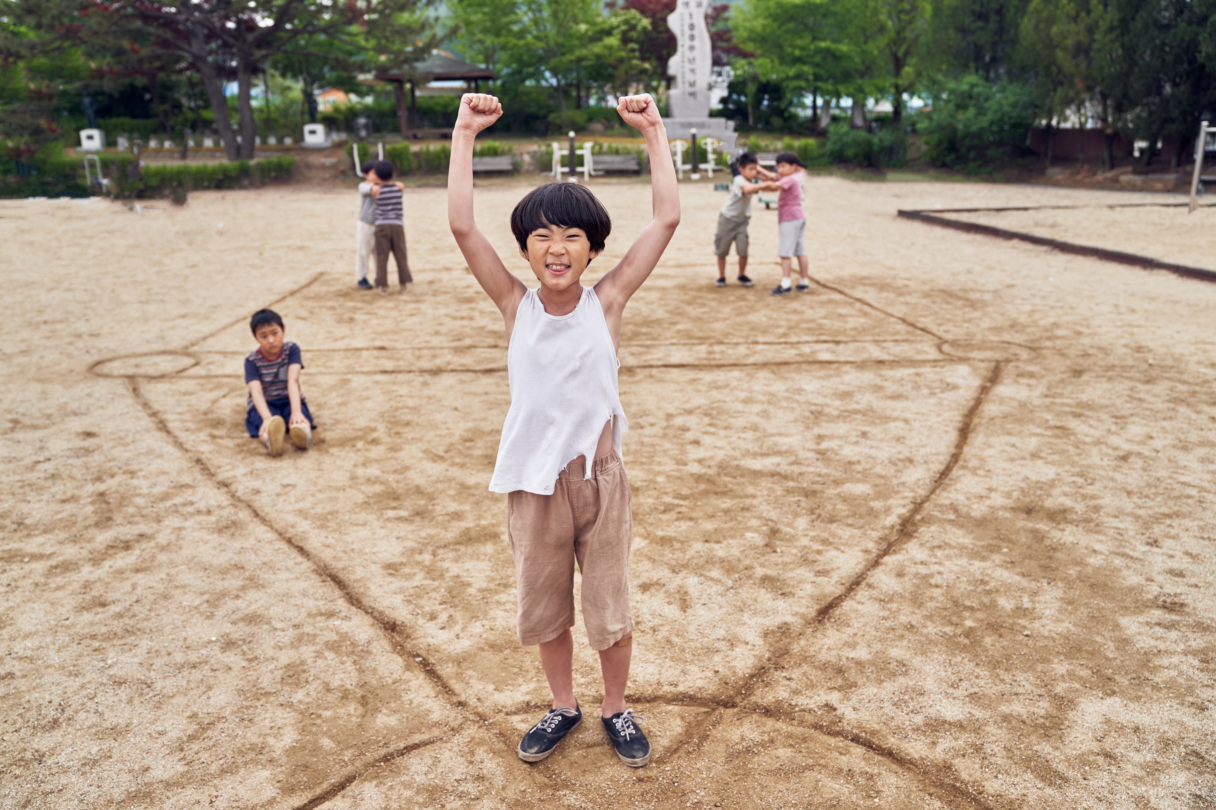 Children playing Squid Game in a sandy playground HD Wallpaper