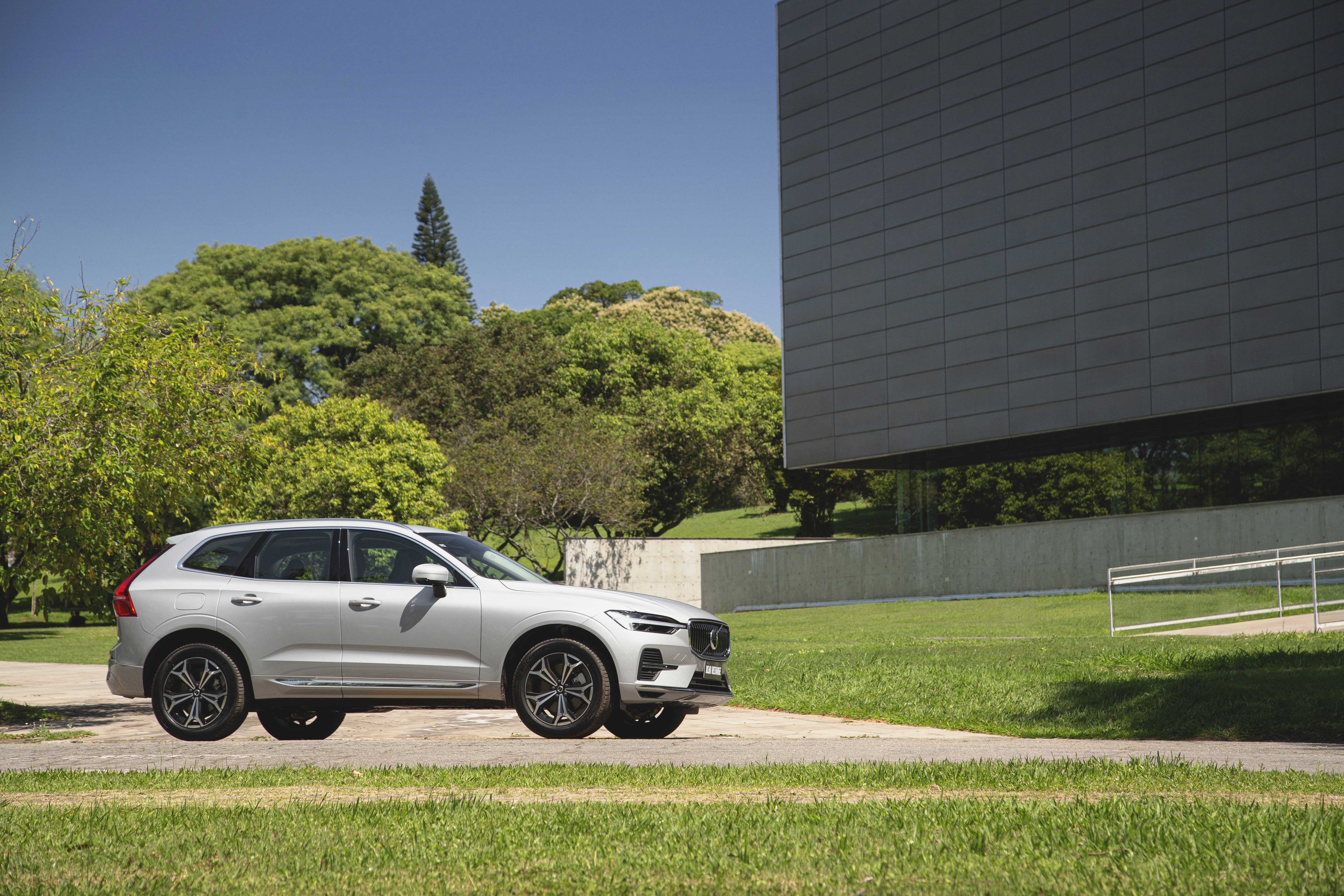 Silver Volvo XC60 SUV parked near a modern building HD Wallpaper