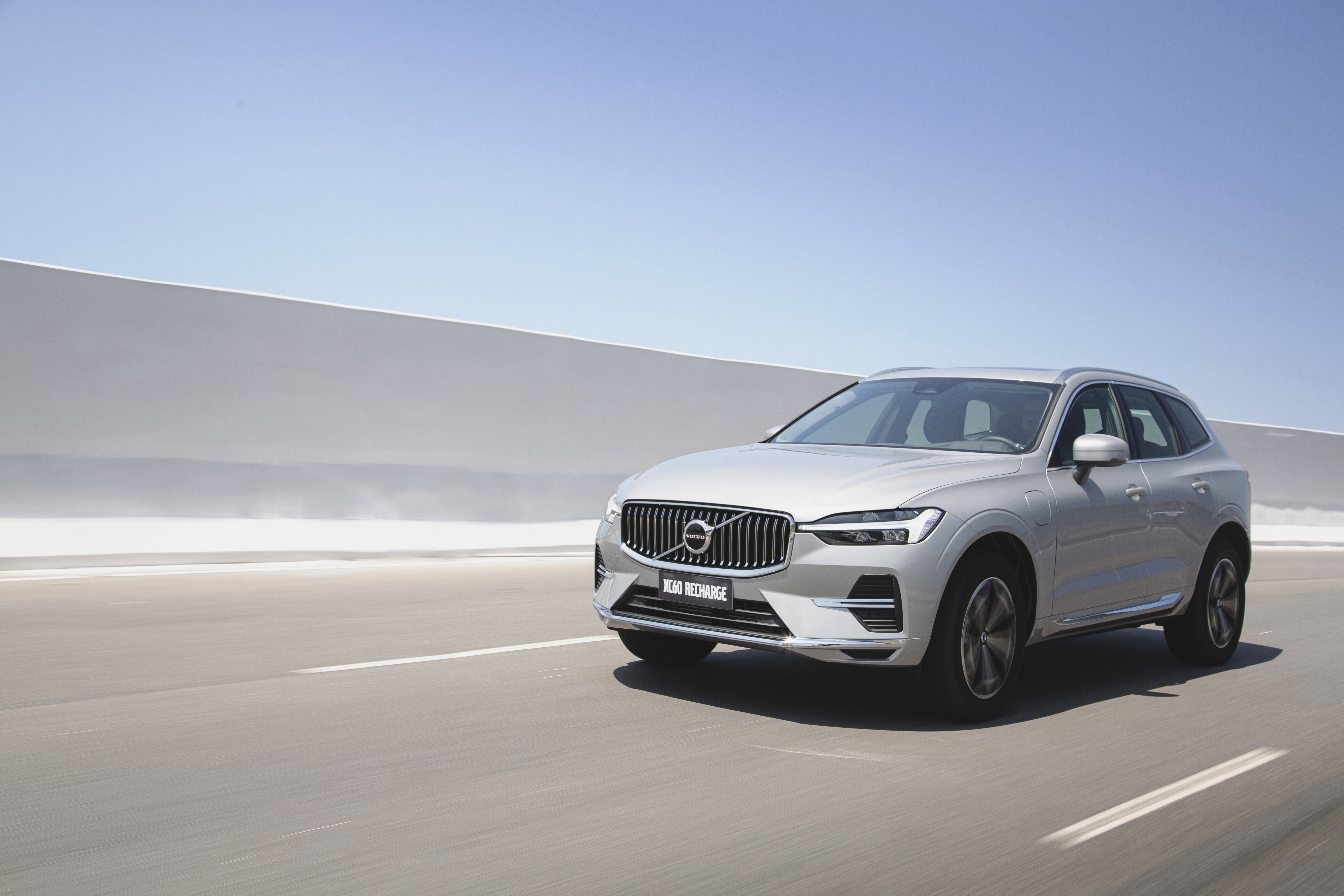 Silver Volvo XC60 Recharge SUV on a highway HD Wallpaper