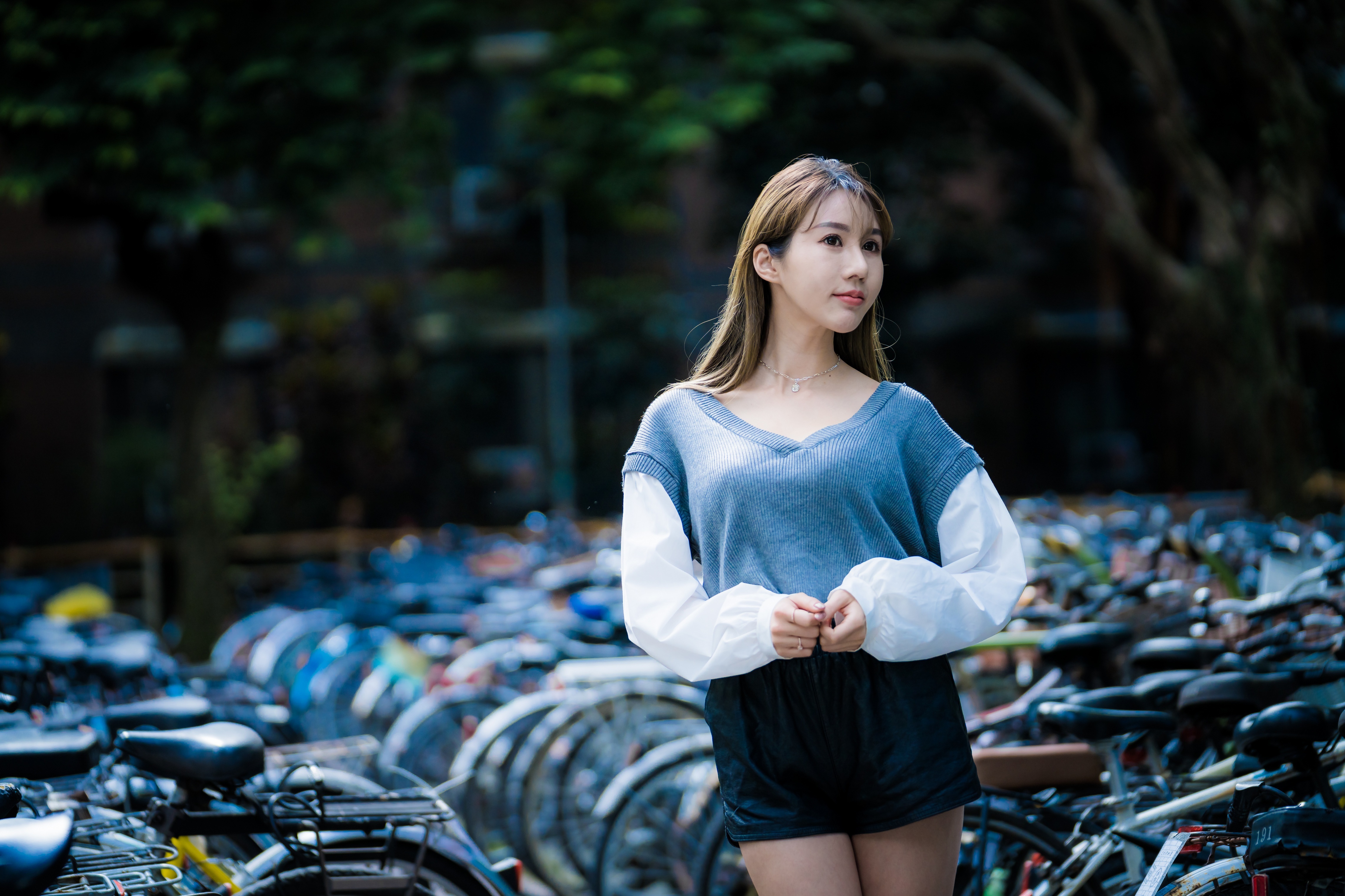 Asian woman in sweater and shorts near bicycles HD Wallpaper