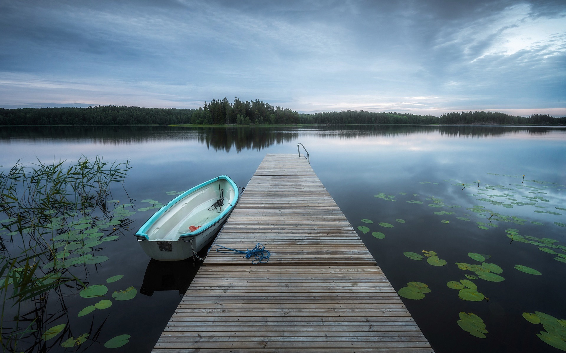 Boat on a wooden dock at a calm lake HD Wallpaper