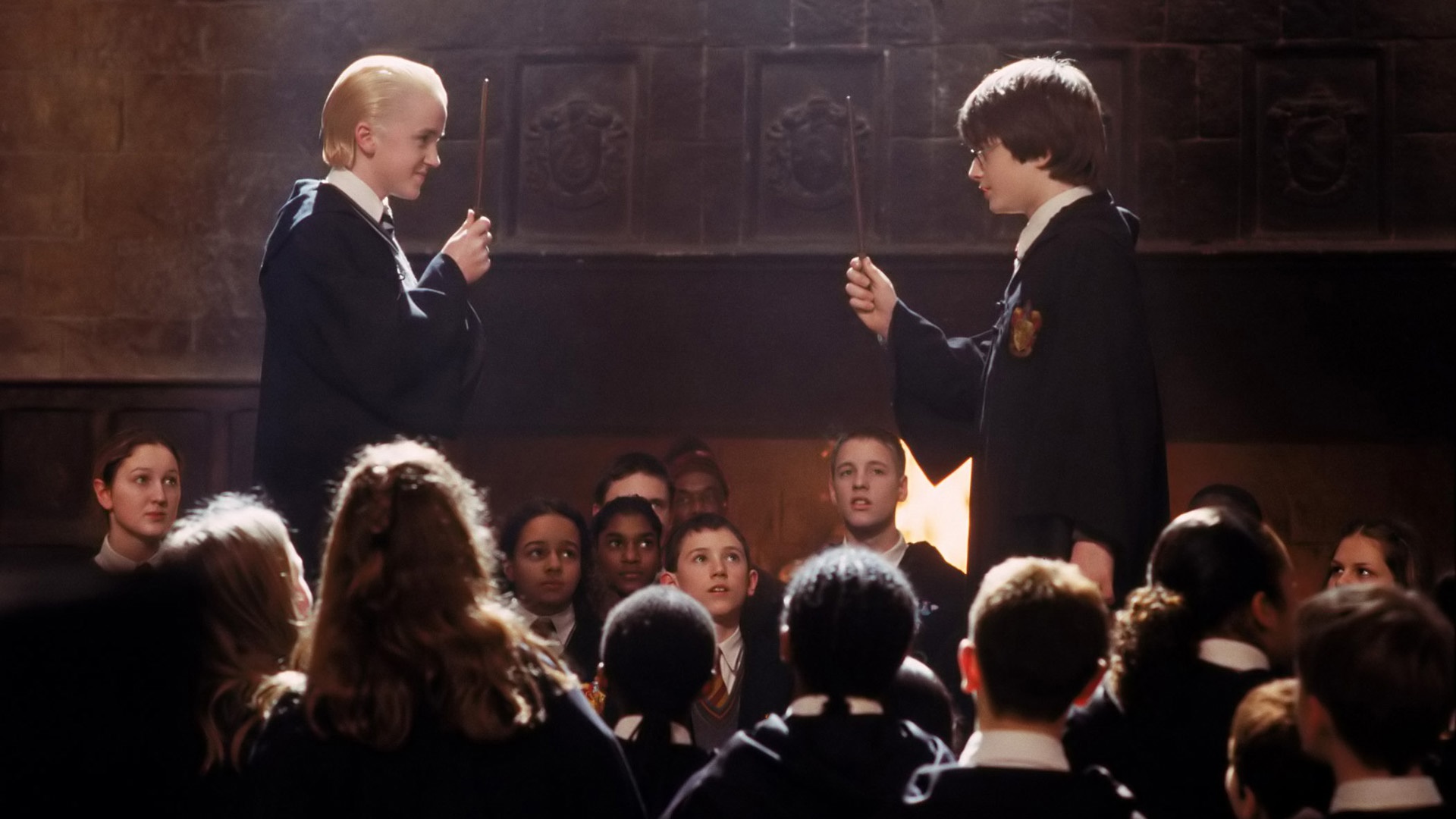 Draco Malfoy and Harry Potter duel in front of students HD Wallpaper