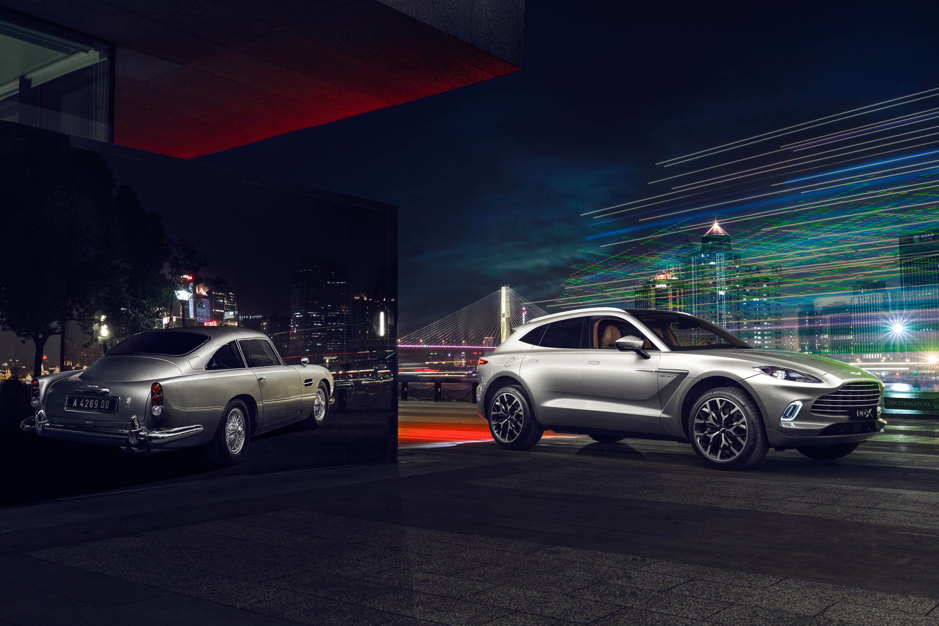 Aston Martin DBX and classic Aston Martin at night HD Wallpaper