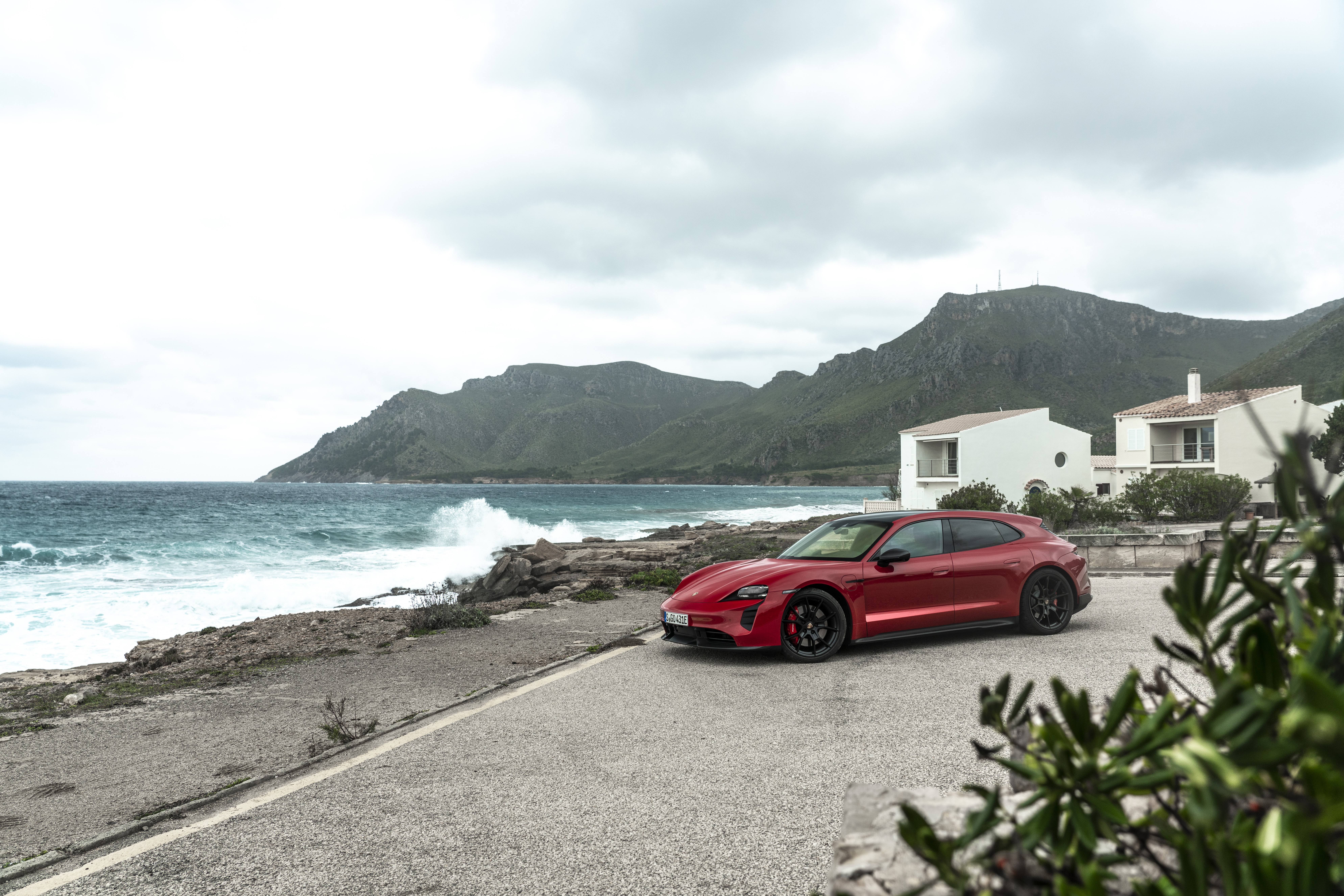 Red Porsche Taycan GTS Sport Turismo on coastal road HD Wallpaper