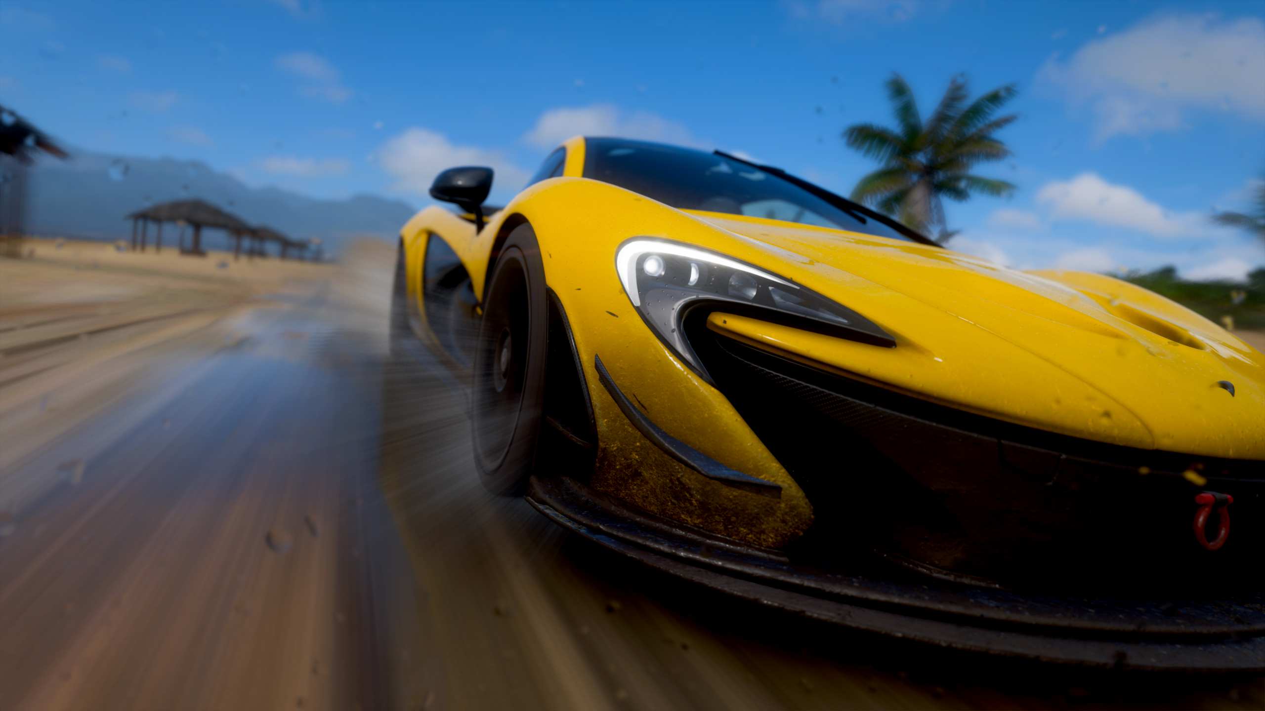 Yellow McLaren P1 driving on a wet beach in Forza Horizon HD Wallpaper