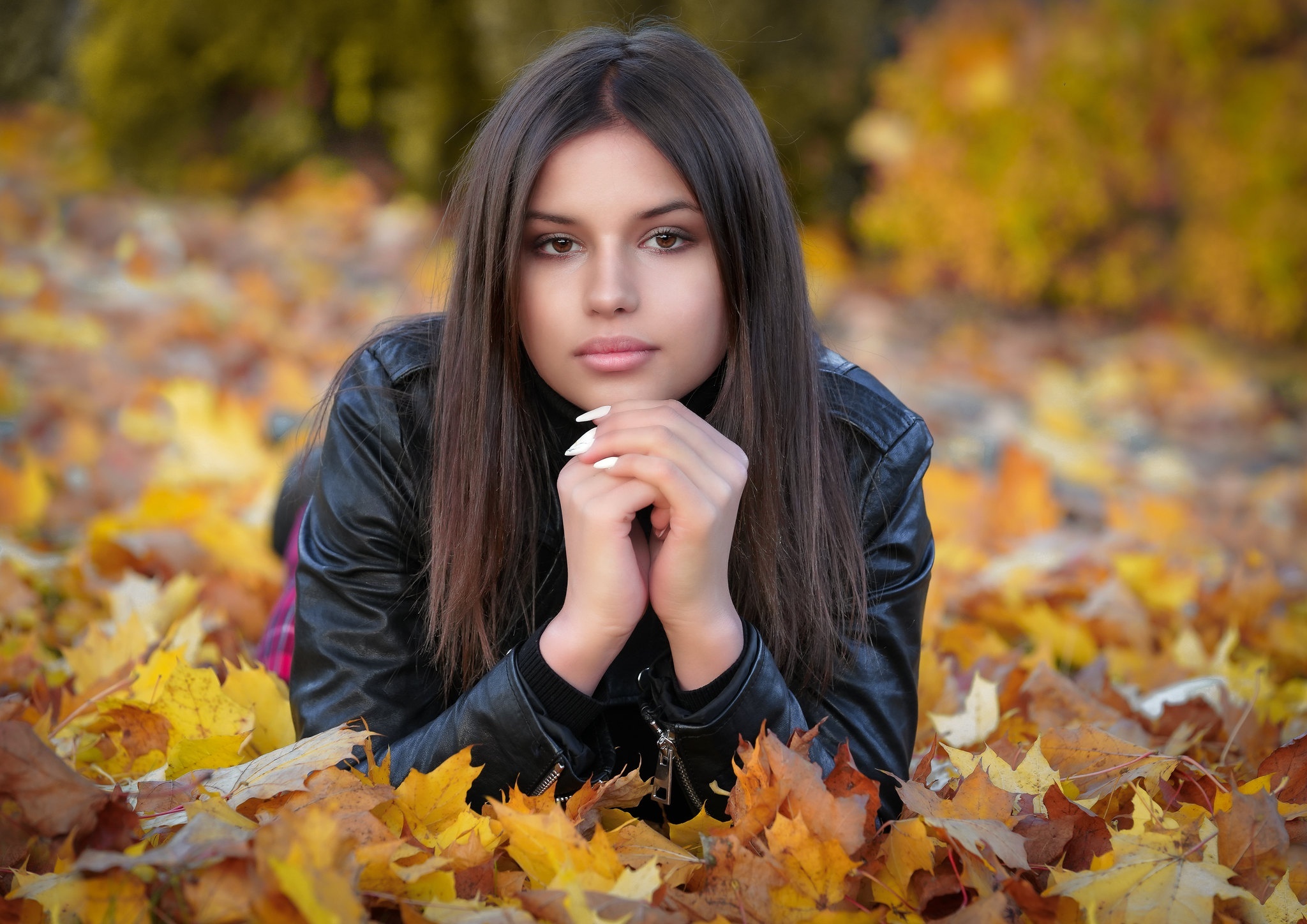 Brunette model lying in autumn leaves HD Wallpaper