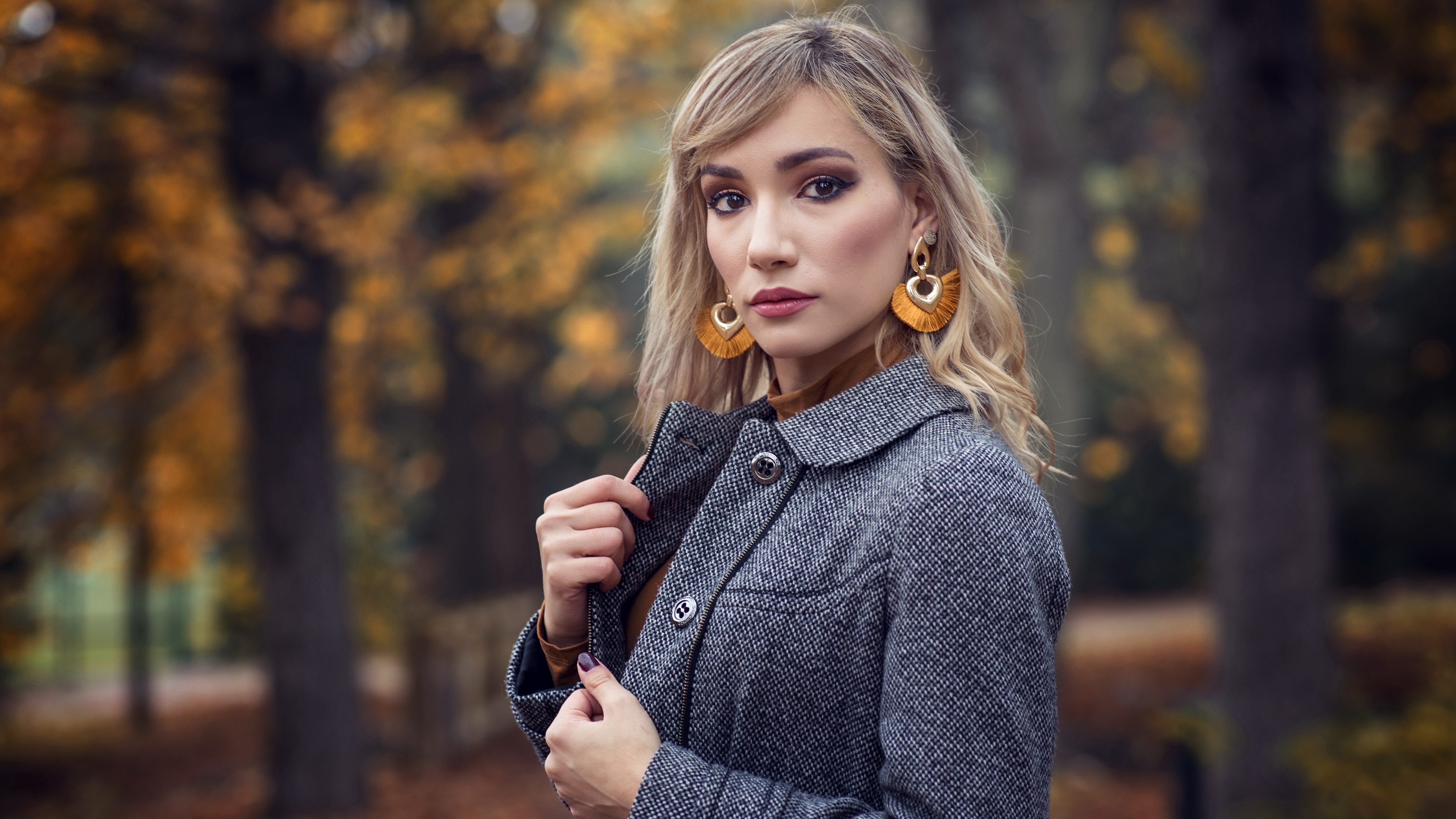Woman with large earrings and coat in autumn park HD Wallpaper