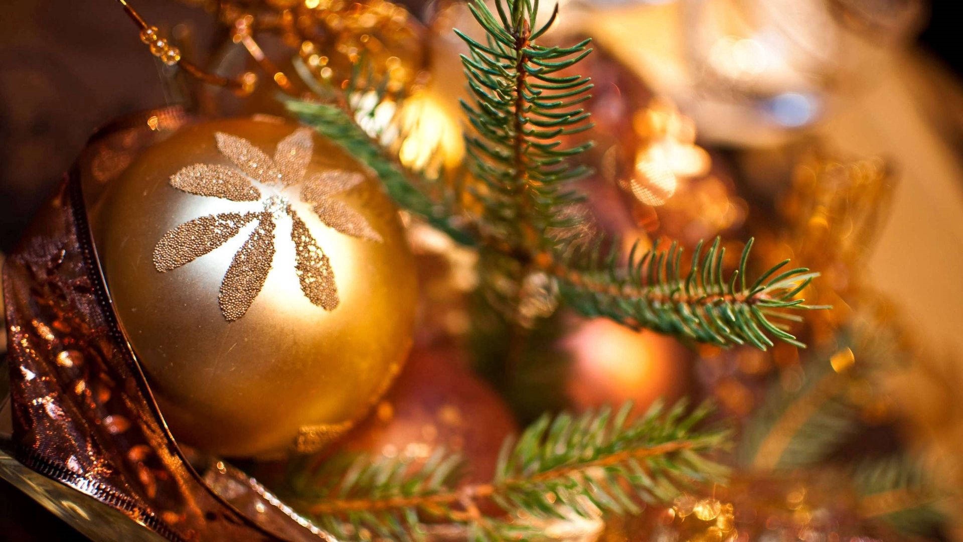 Close-up of golden Christmas ornaments and pine needles HD Wallpaper