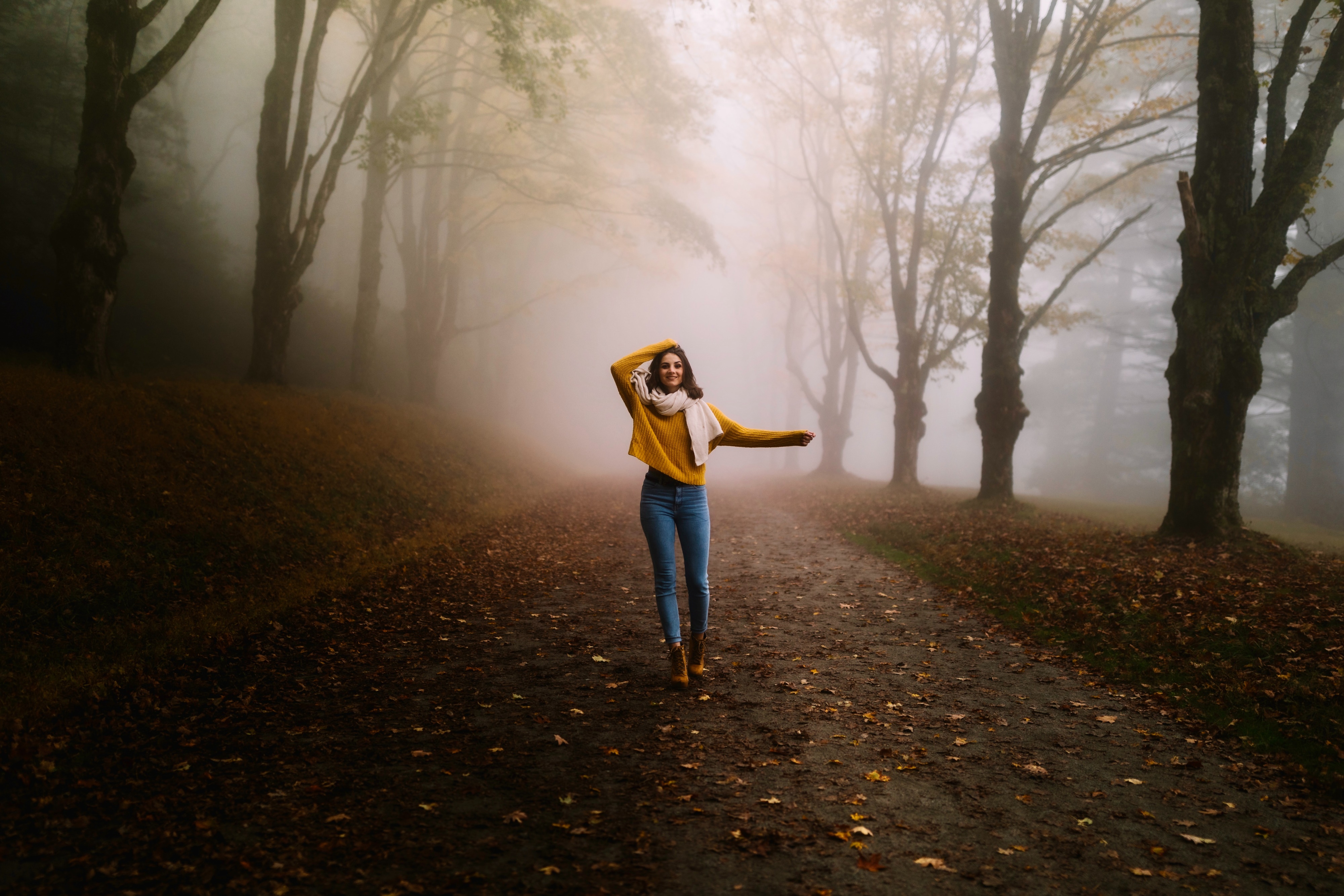 Woman in yellow sweater walking in foggy forest 4K HD Wallpaper