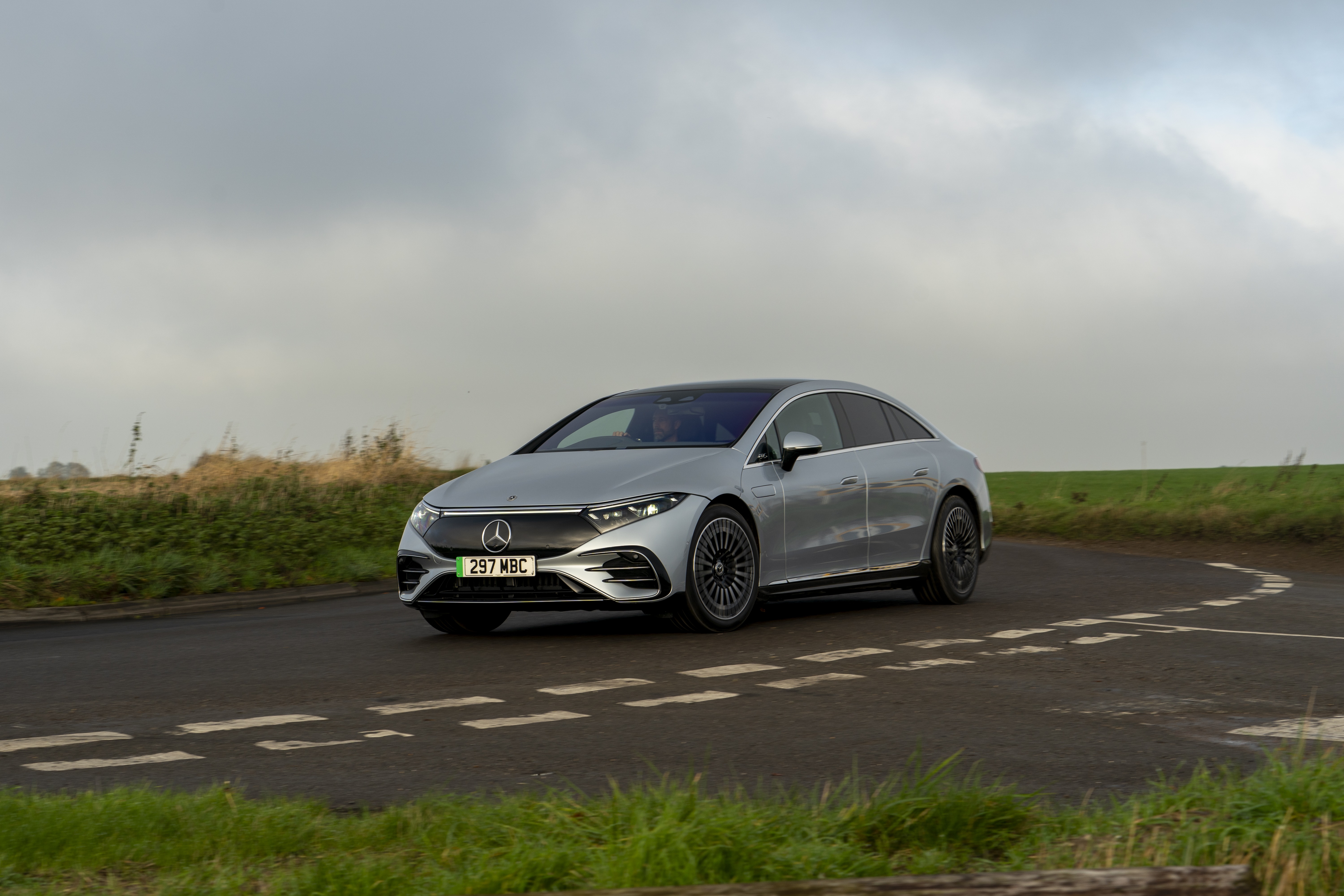 Silver Mercedes-Benz EQS 450 AMG Line driving on a road HD Wallpaper
